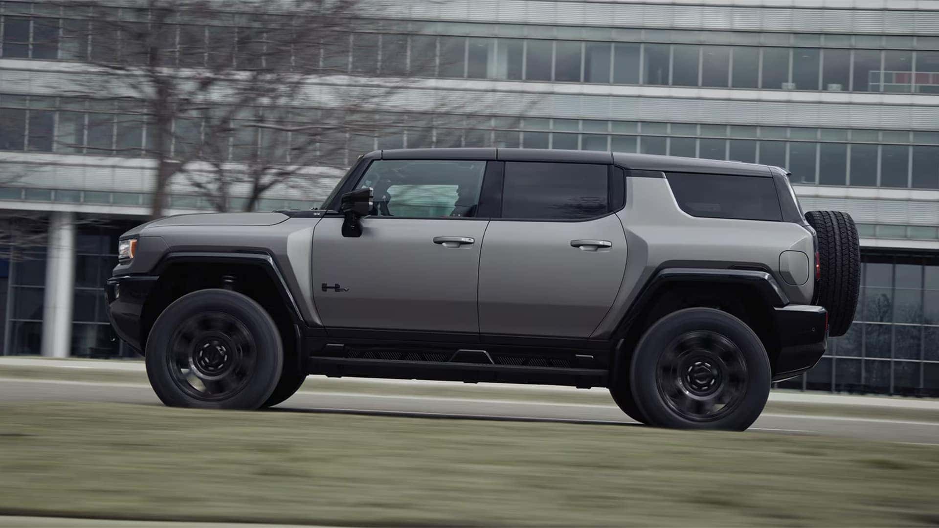 2026 GMC HUMMER EV SUV side profile in motion showing electric performance and road presence