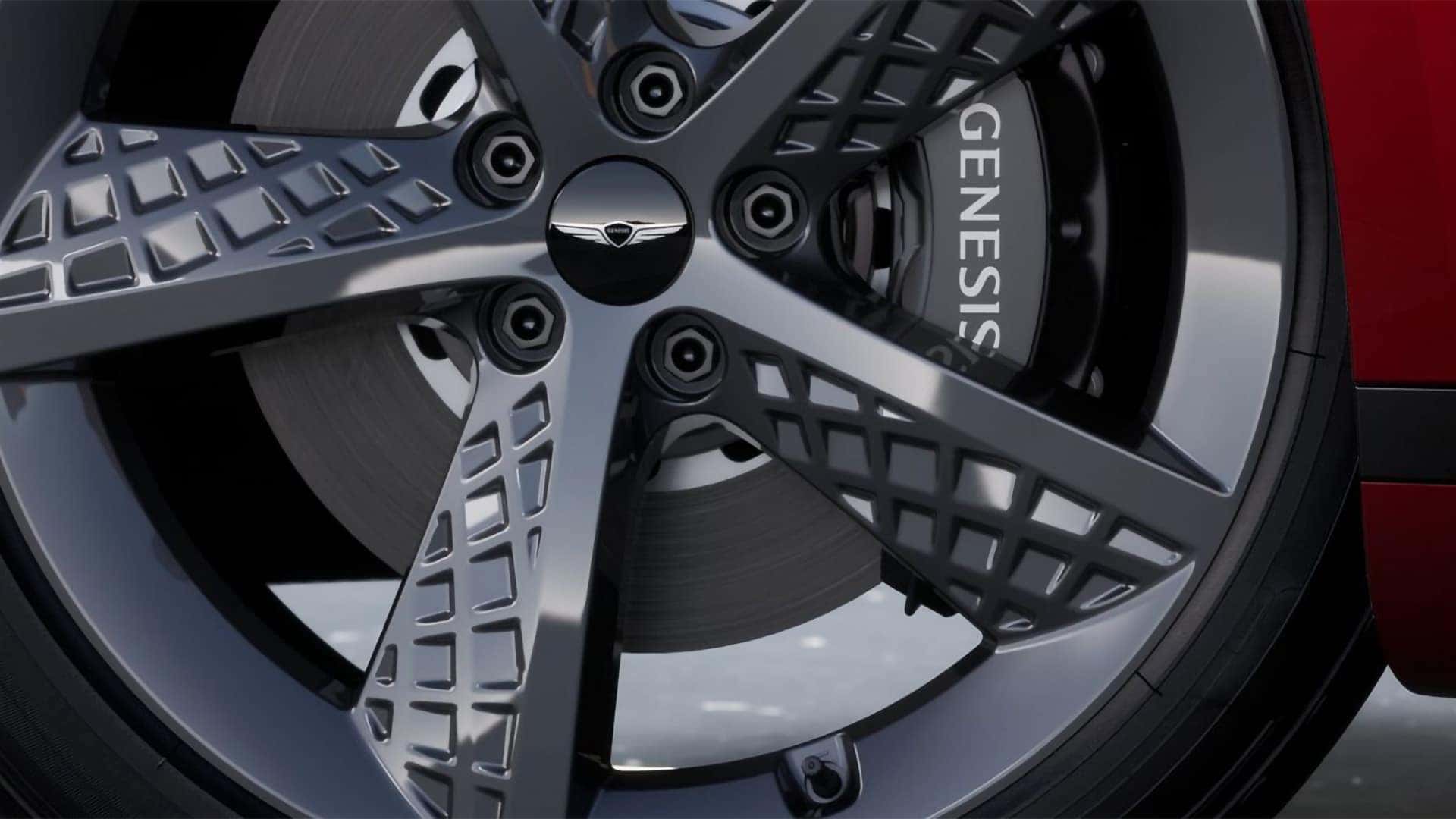 Close up of 2026 Genesis G80 alloy wheel with intricate spoke design and Genesis branded brake caliper