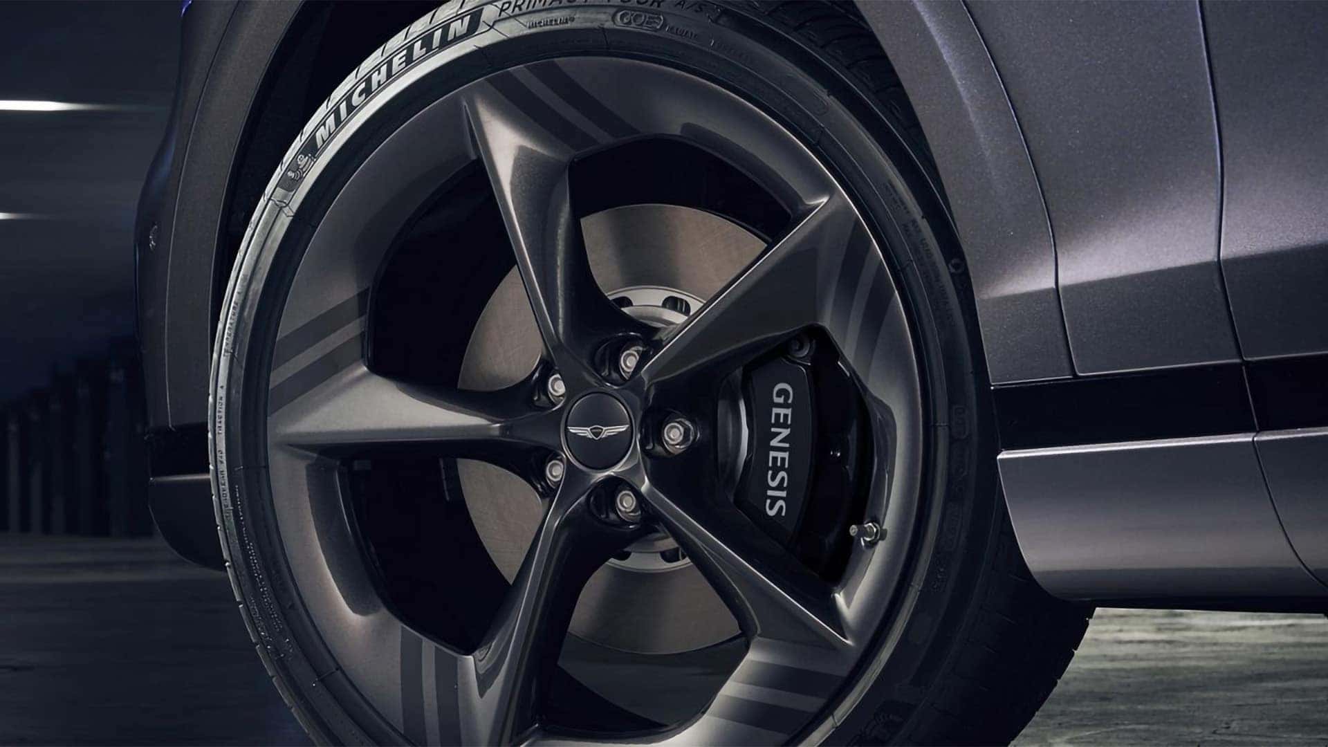 Close up of 2026 Genesis GV70 21 inch sport alloy wheel with Genesis branded brake caliper