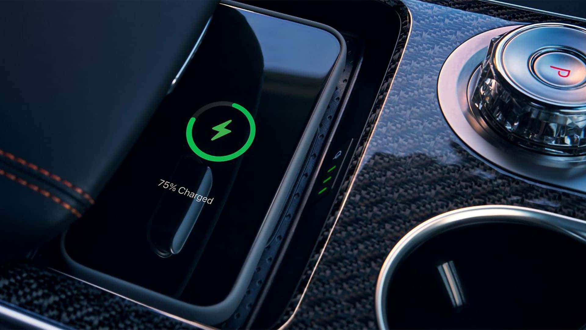 2026 Genesis GV70 wireless charging pad with smartphone charging beside the rotary gear selector