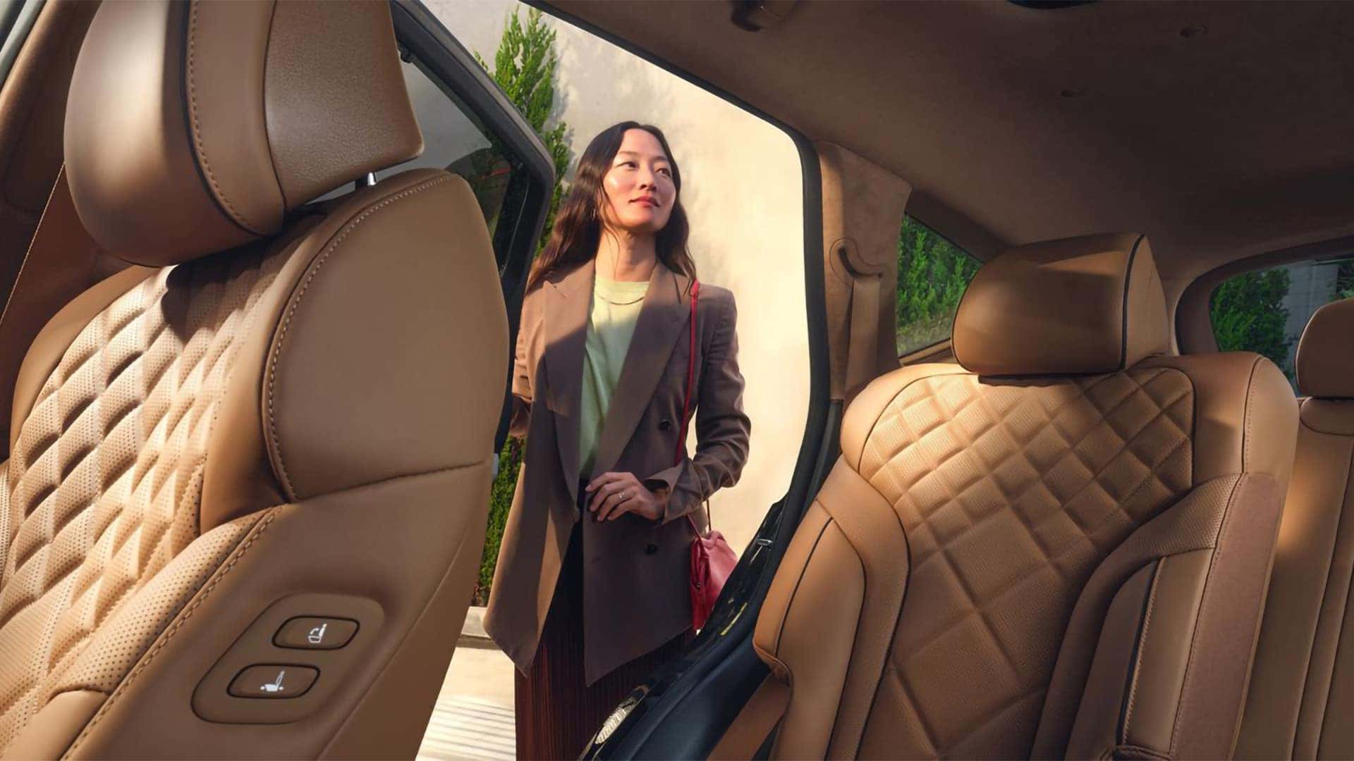 2026 Genesis GV80 rear seat area with premium leather upholstery and passenger entering through open door