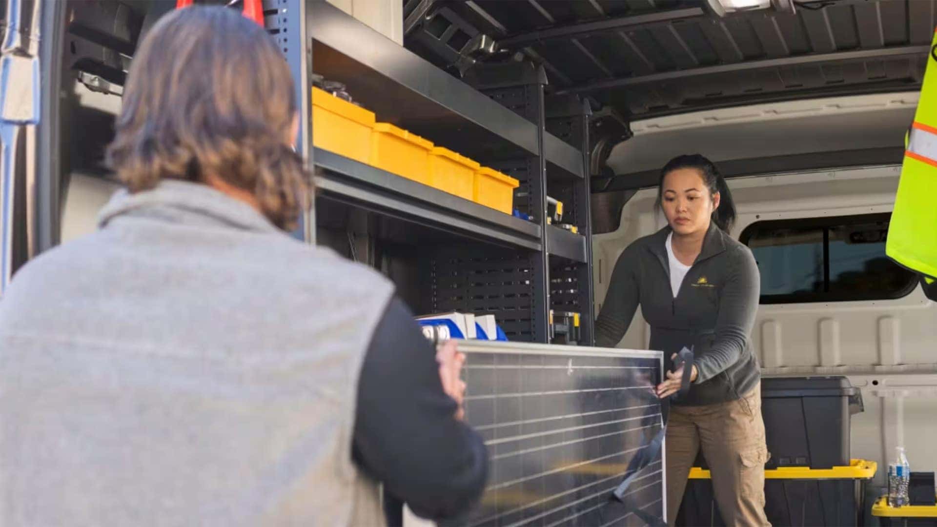 Workers loading equipment into the cargo area of a 2026 RAM ProMaster Cargo Van