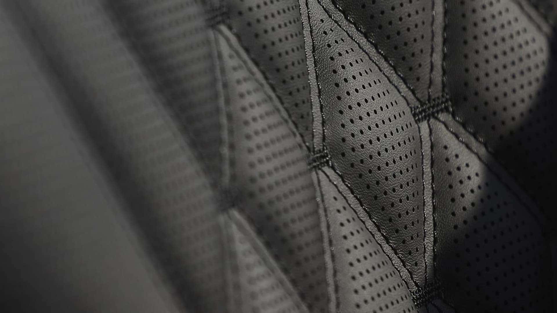 Close-up of Genesis G80 perforated leather seat with diamond-pattern stitching and premium material detail