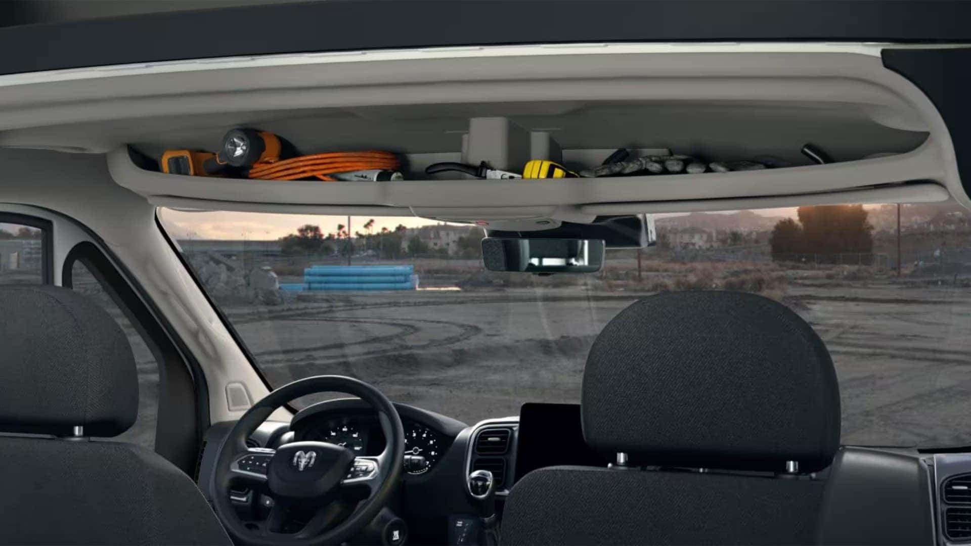 2026 RAM ProMaster interior with overhead storage shelf holding tools and equipment above the driver area