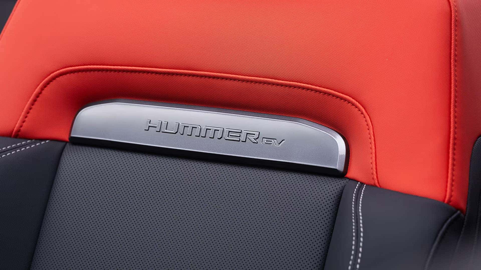 2026 GMC HUMMER EV SUV interior materials with red and black leather seating and HUMMER EV trim accent