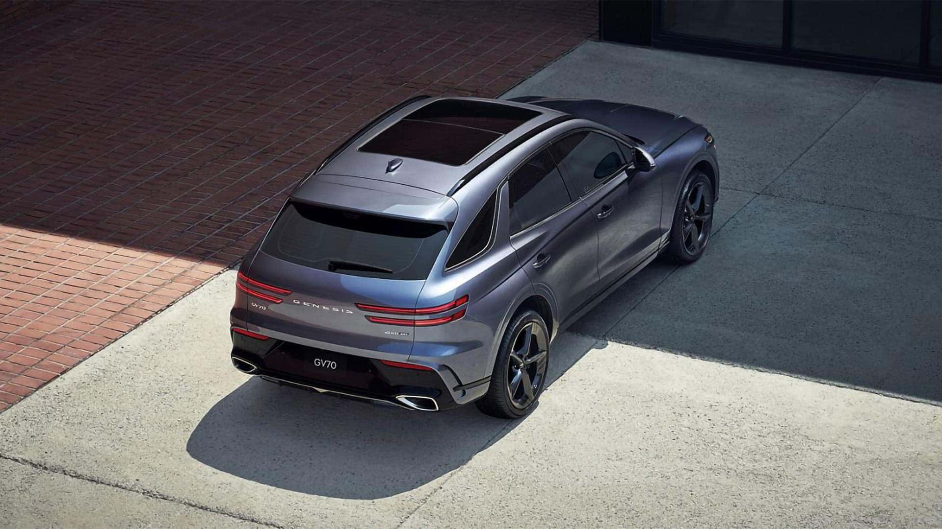 2026 Genesis GV70 rear three quarter view from above, showing taillights, roofline, and overall SUV design