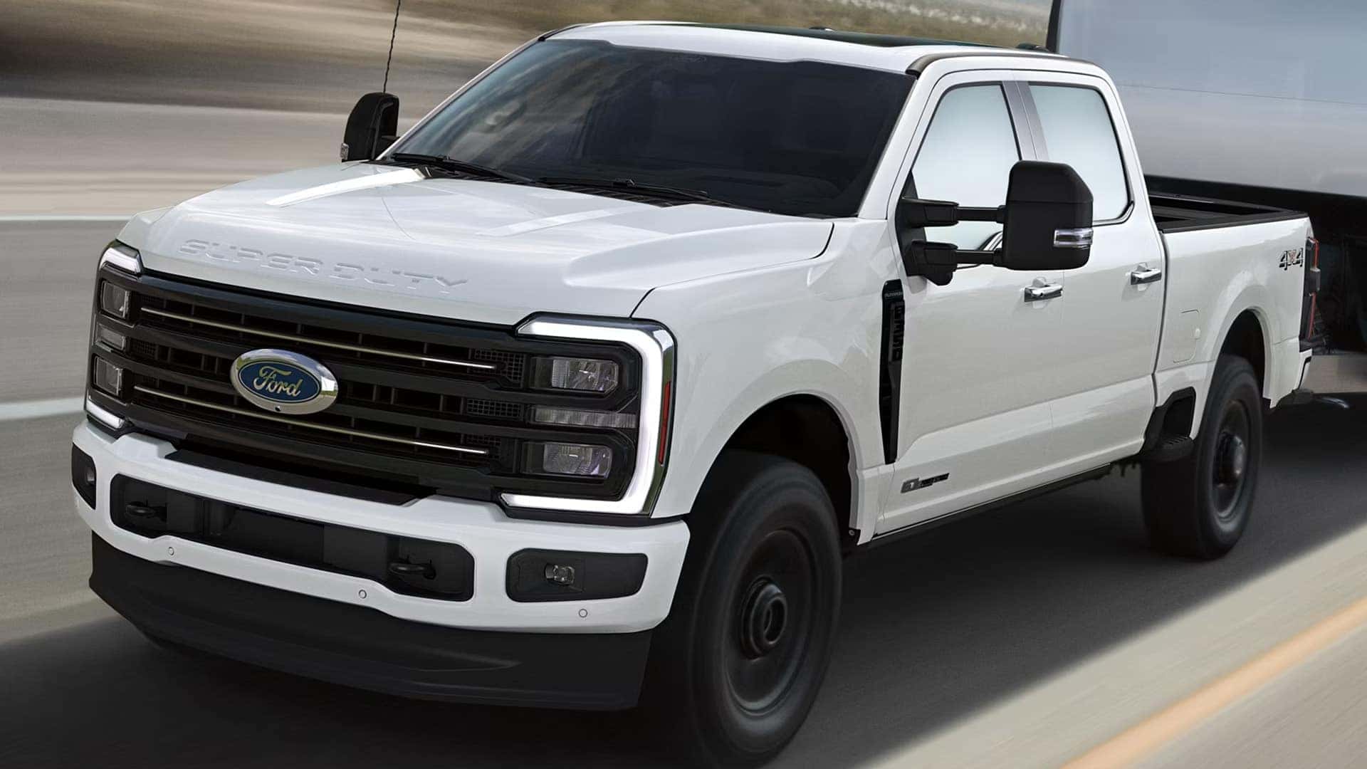 White 2026 Ford F-350 Super Duty XL driving on highway, showing base trim exterior, black grille, and work truck styling