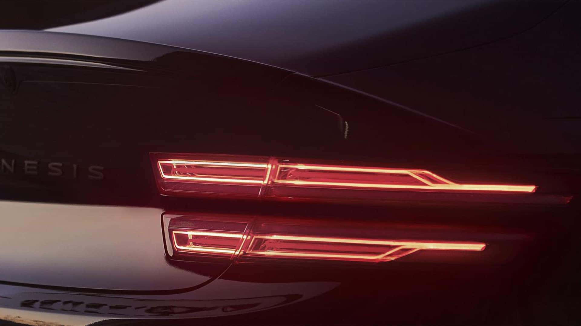 Close up of 2026 Genesis G80 rear two-line LED tail lights illuminated at night