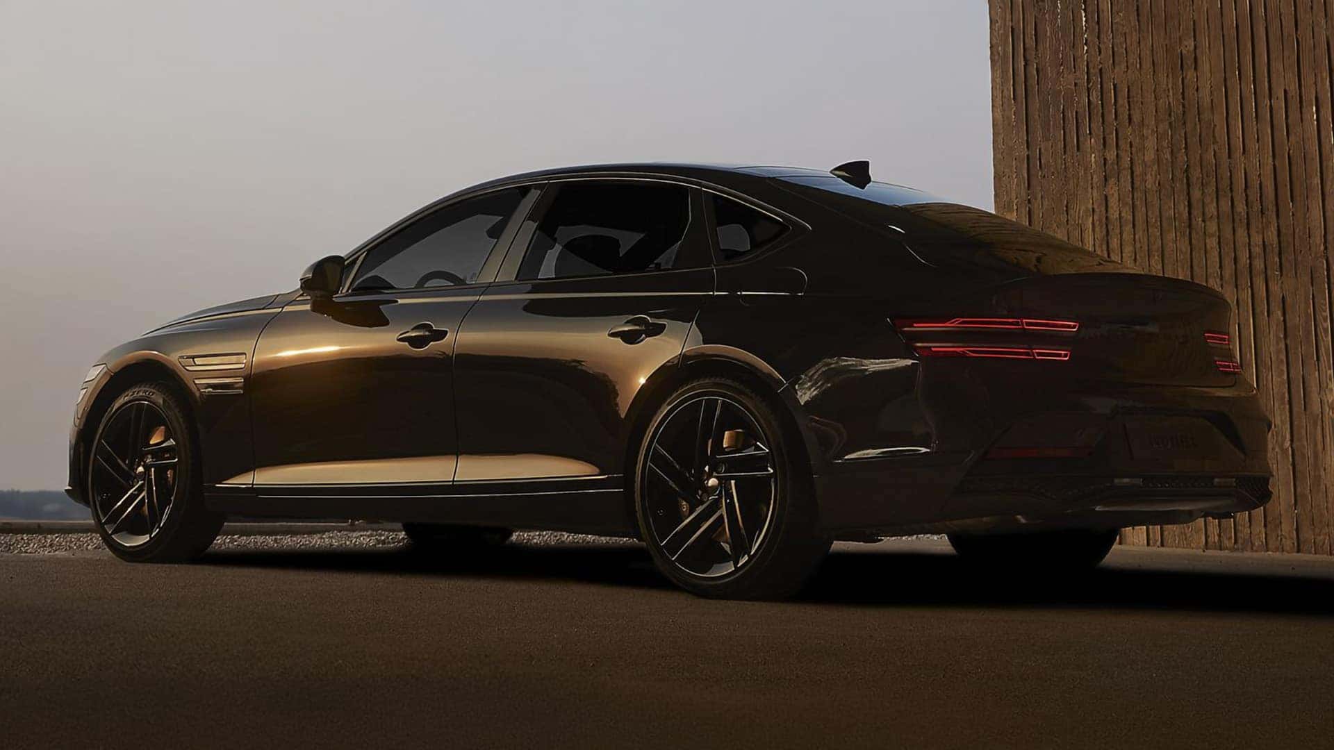 2026 Genesis G80 rear three quarter view in dark finish with LED taillights and sport styling details