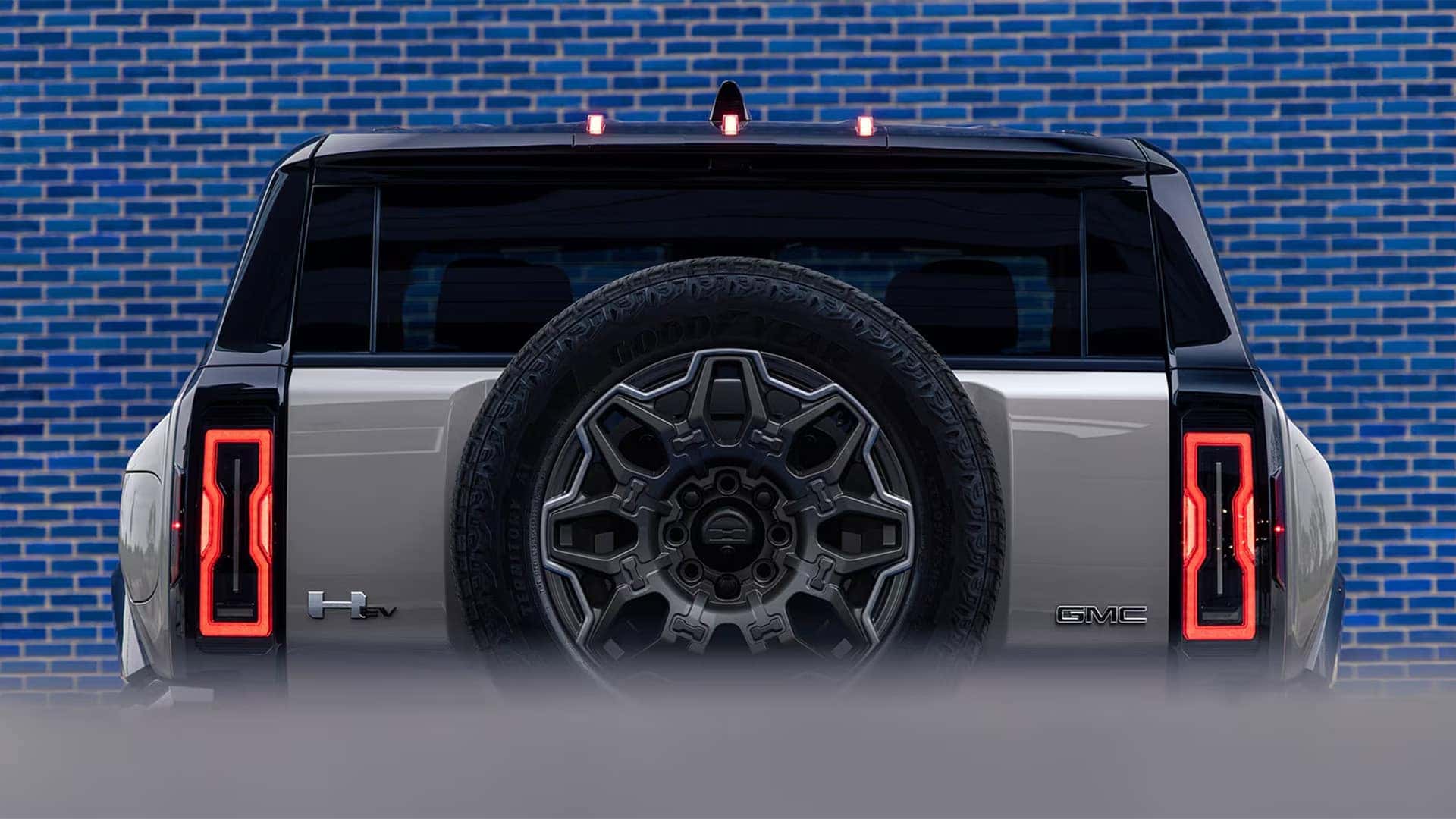 2026 GMC HUMMER EV SUV rear view with spare tire and LED taillights highlighting design and capability