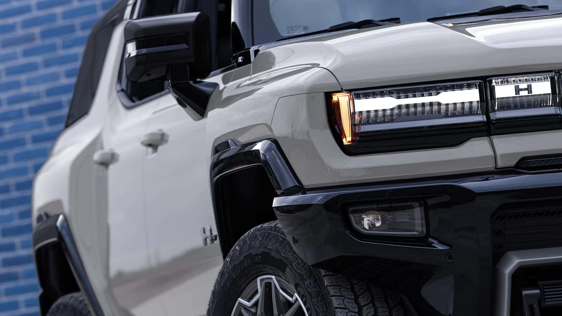 Close-up of 2026 GMC HUMMER EV SUV front headlight and fender design highlighting rugged styling details