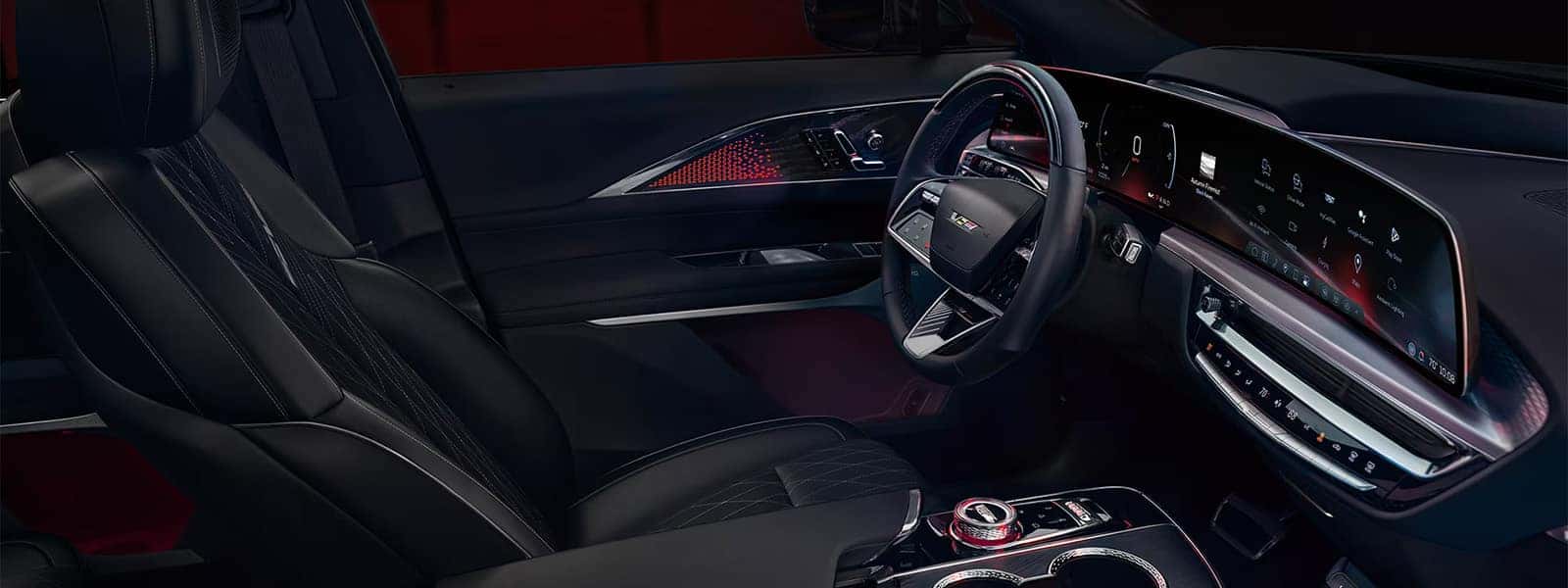 2026 Cadillac LYRIQ interior with black seats, 33-inch curved display, steering wheel controls, and illuminated cabin accents