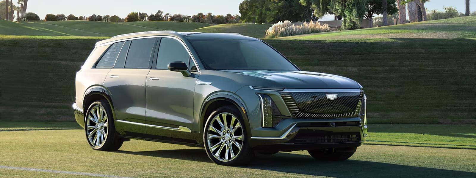 2026 Cadillac VISTIQ electric SUV parked on a golf course, showing a front three quarter view and luxury exterior design