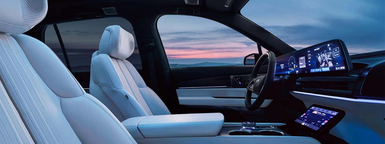 2026 Cadillac VISTIQ interior with white front seats, curved 33-inch display, ambient lighting, and luxury EV cabin design