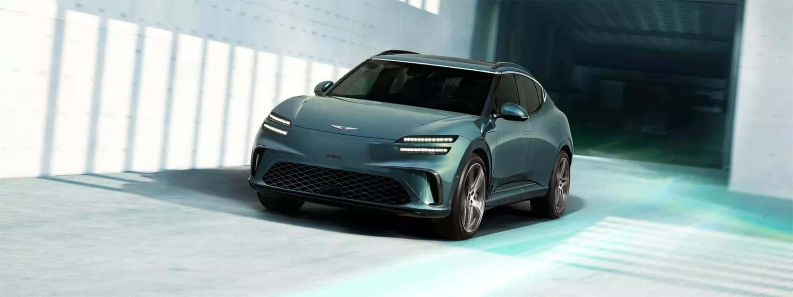 2026 Genesis GV60 electric luxury SUV driving through a modern tunnel with signature LED lighting