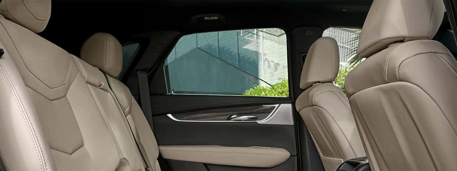 2026 Cadillac XT5 interior with beige leather seating, rear passenger space, and premium two-row SUV cabin design