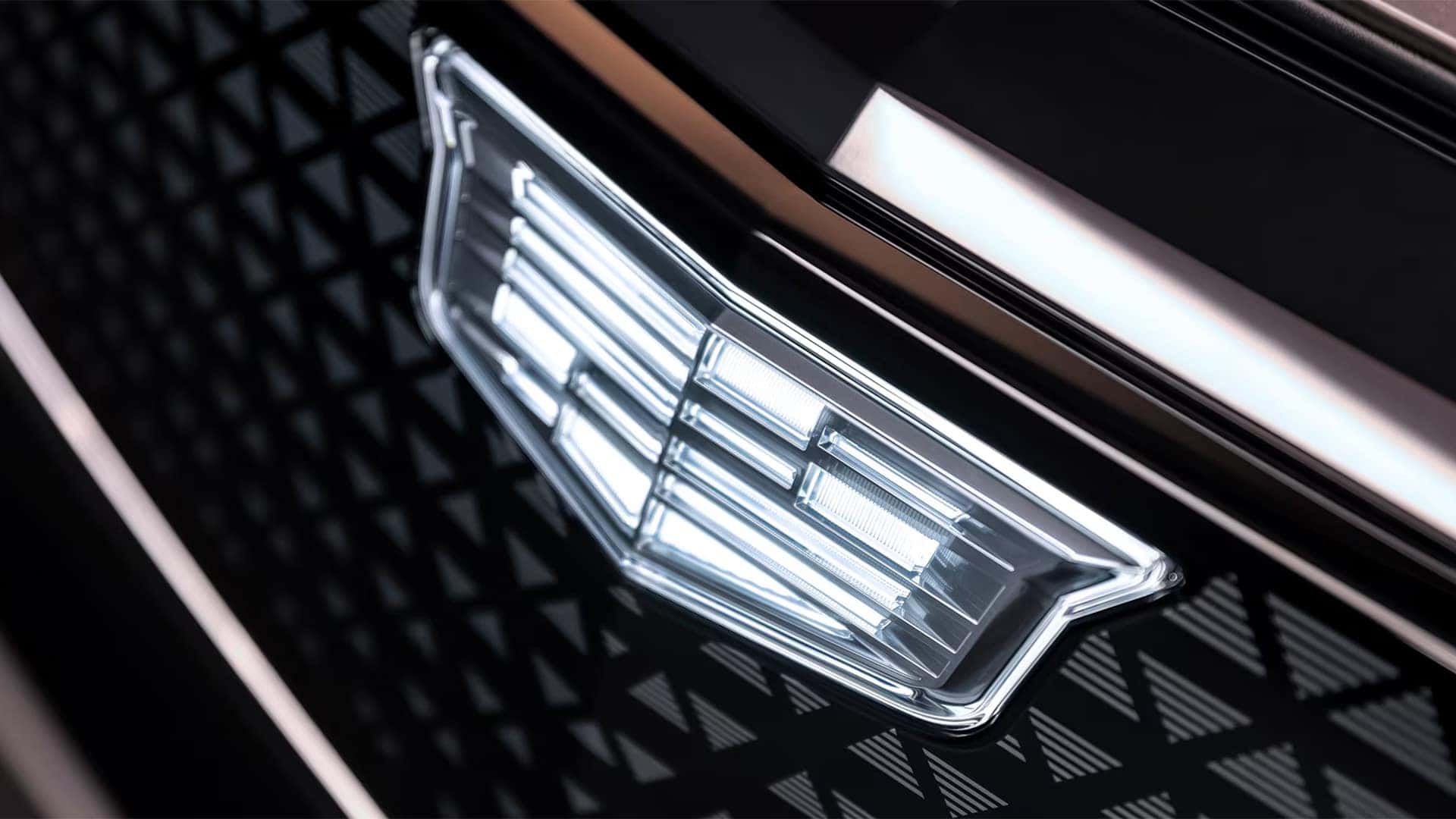 Close up of the 2026 Cadillac LYRIQ illuminated front grille and Cadillac crest with detailed black crystal styling