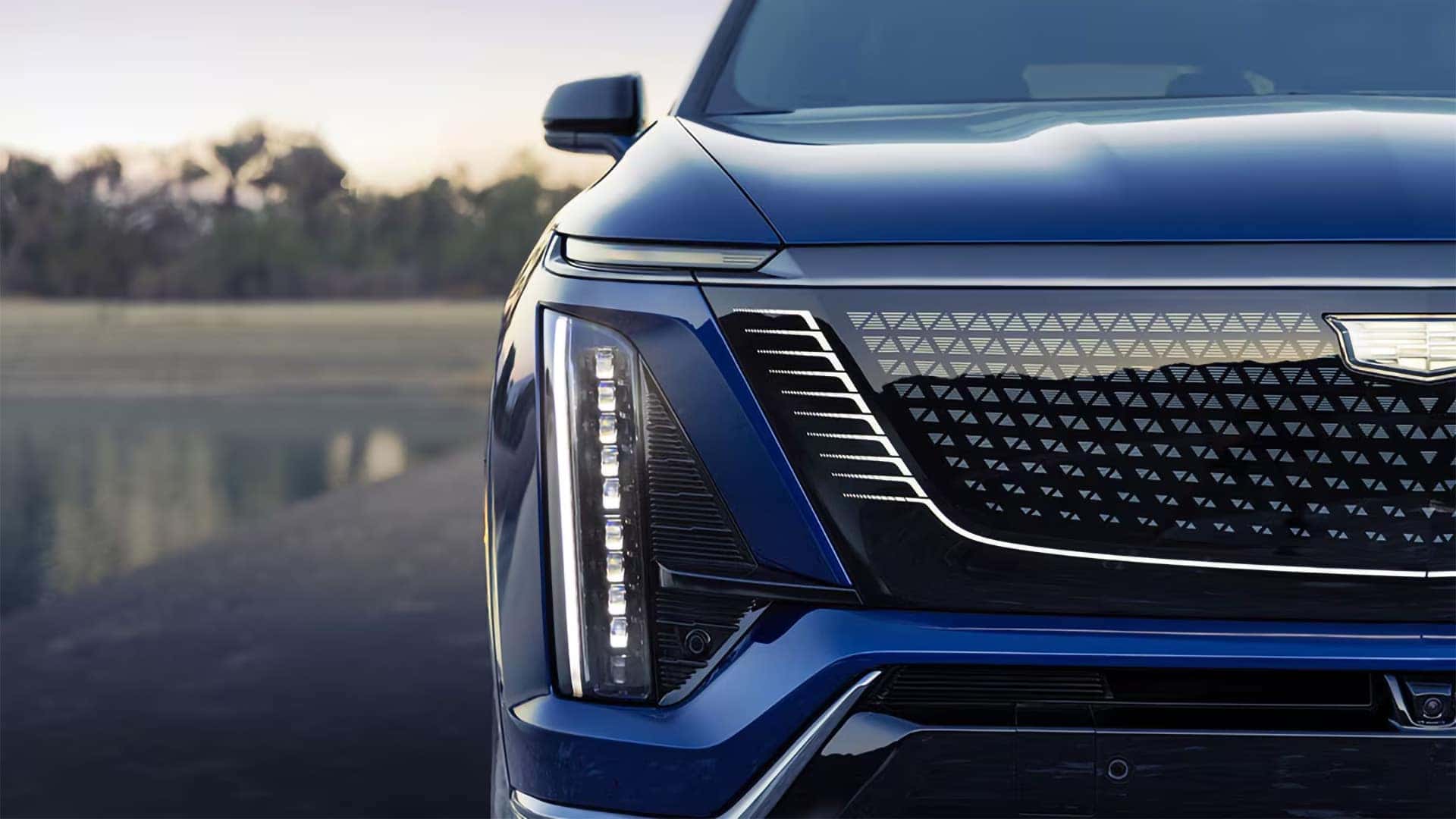 Close up of the 2026 Cadillac VISTIQ front grille, Cadillac crest, vertical LED lighting, and sculpted electric SUV front fascia