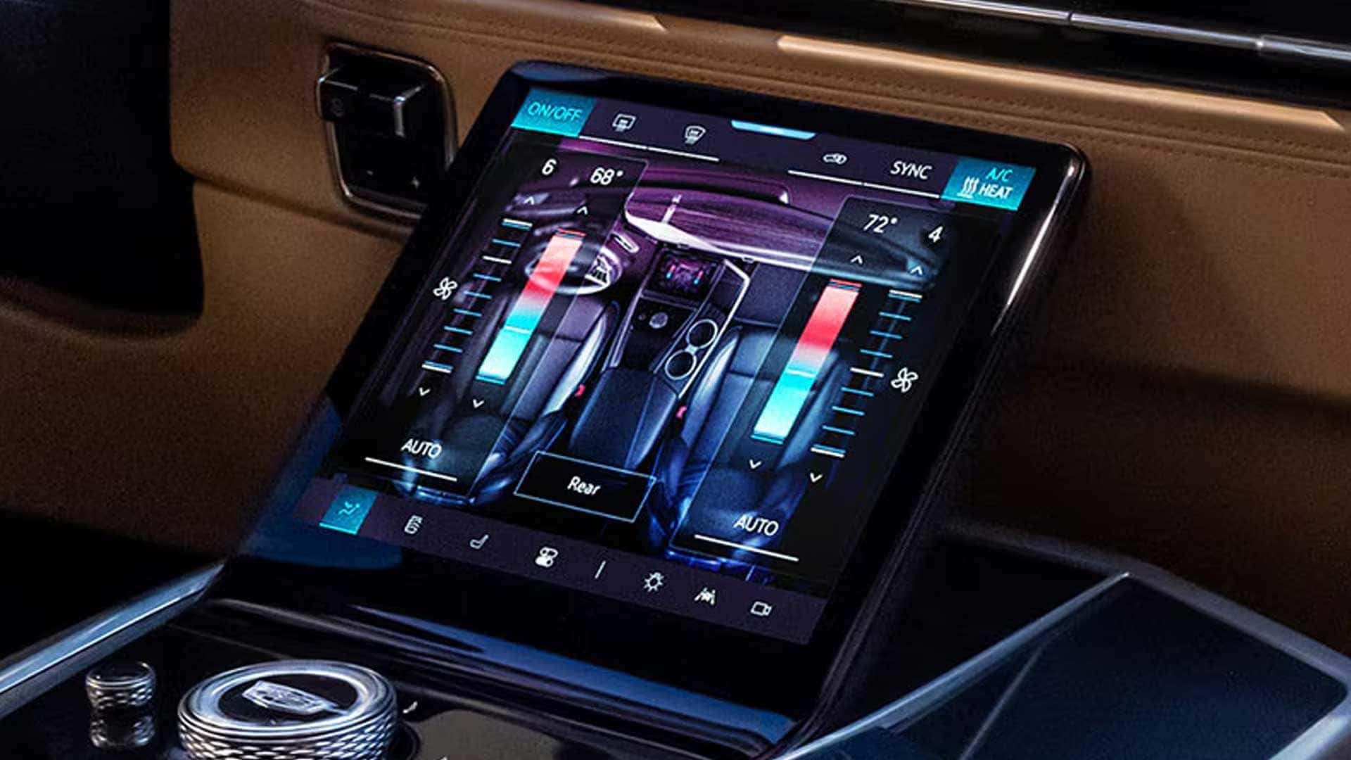 Close-up of center touchscreen showing climate controls beside rotary dial and glossy console trim
