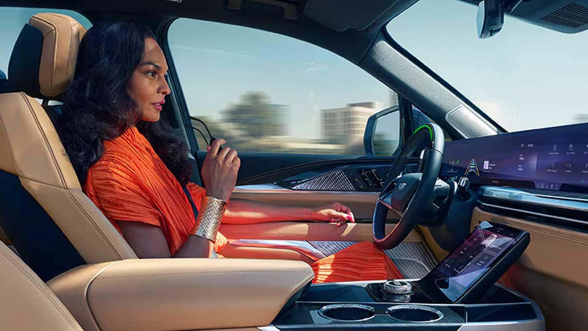 Driver seated hands-free in Cadillac Escalade IQ with green steering wheel light and wide display