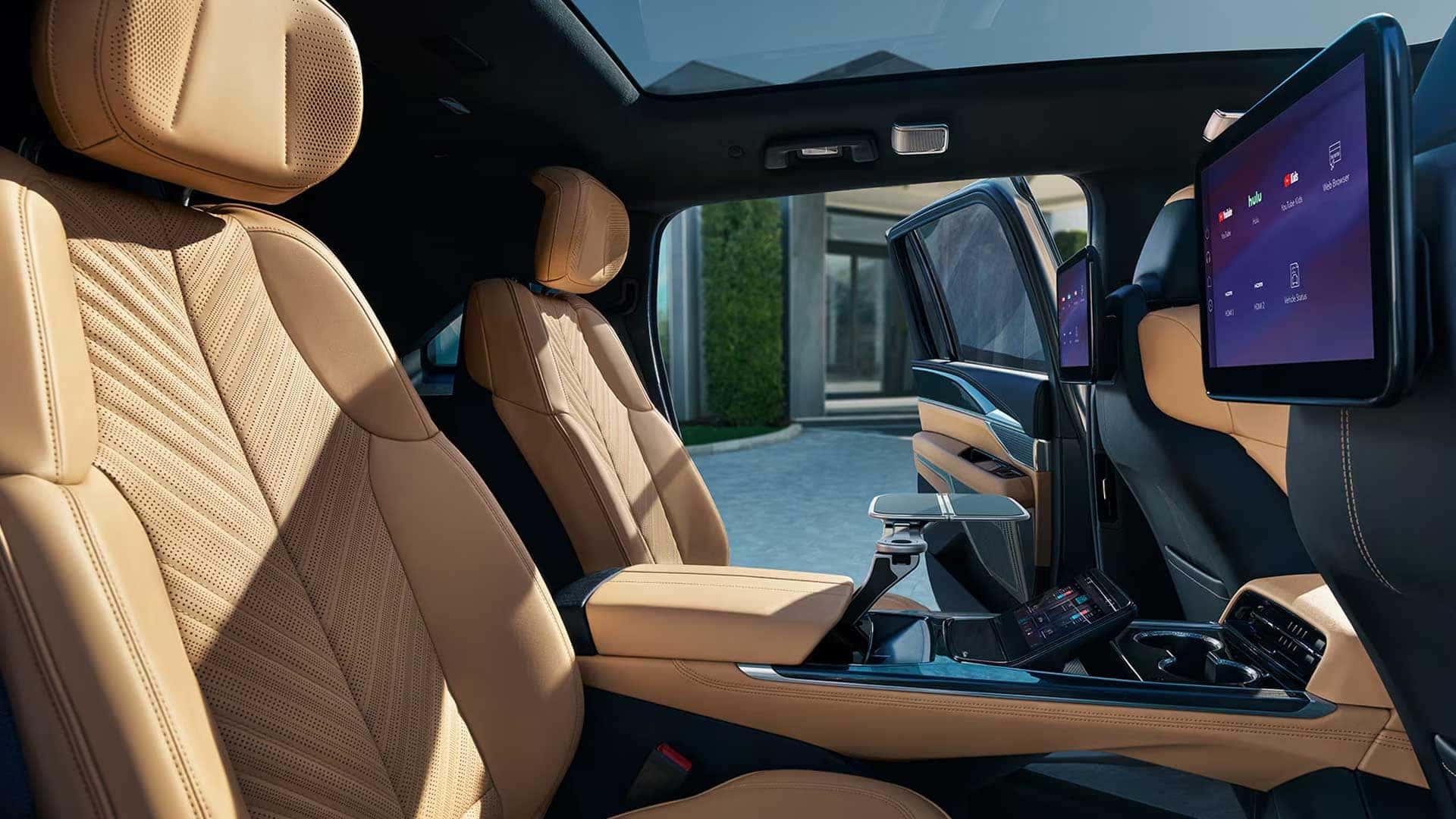 Rear cabin with two captain chairs, center console, and digital screens in Cadillac Escalade IQ