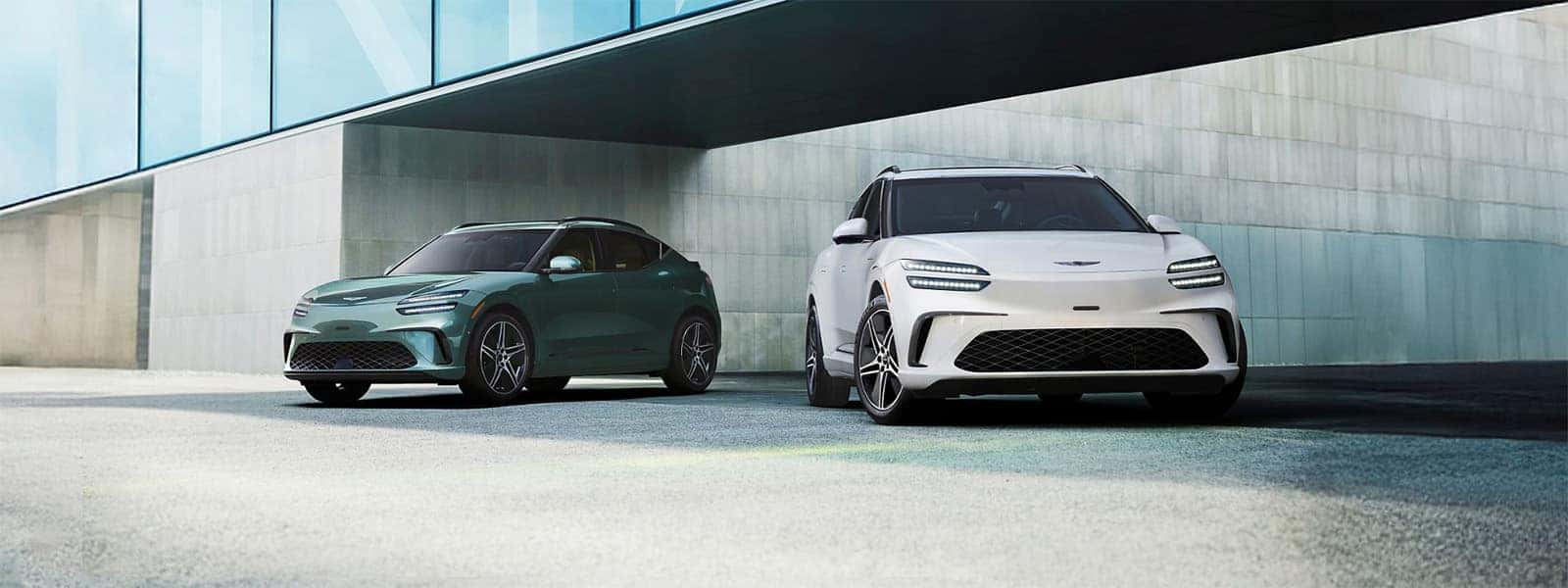 2026 Genesis GV60 electric SUVs parked near a modern building, front three quarter view