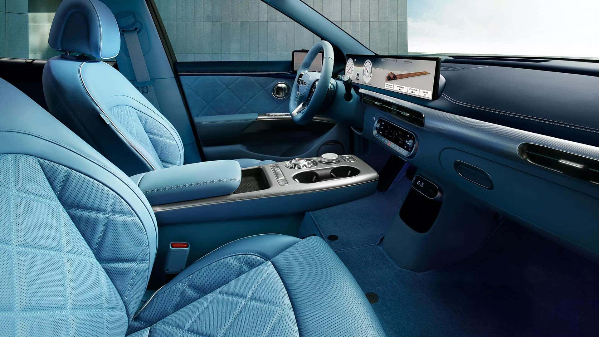 2026 Genesis GV60 interior with blue quilted seats, wide digital display, and premium front cabin design
