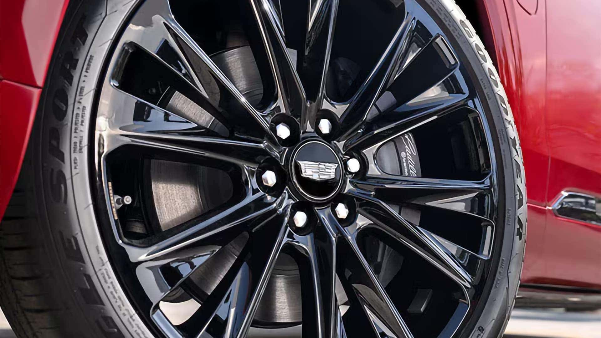 Close up of a black 2026 Cadillac VISTIQ wheel with Cadillac center cap and visible Brembo brake caliper