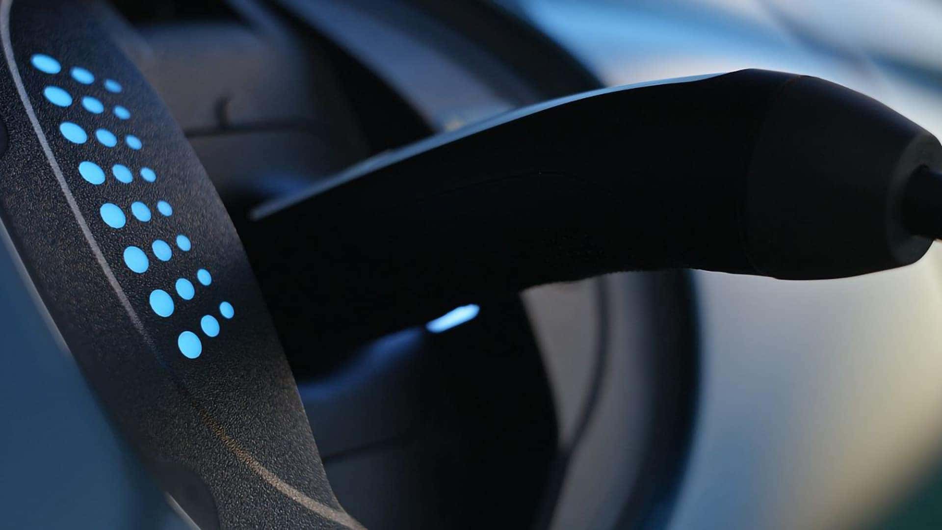 2026 Genesis GV60 charging port close-up showing EV charging connection with blue indicator lights
