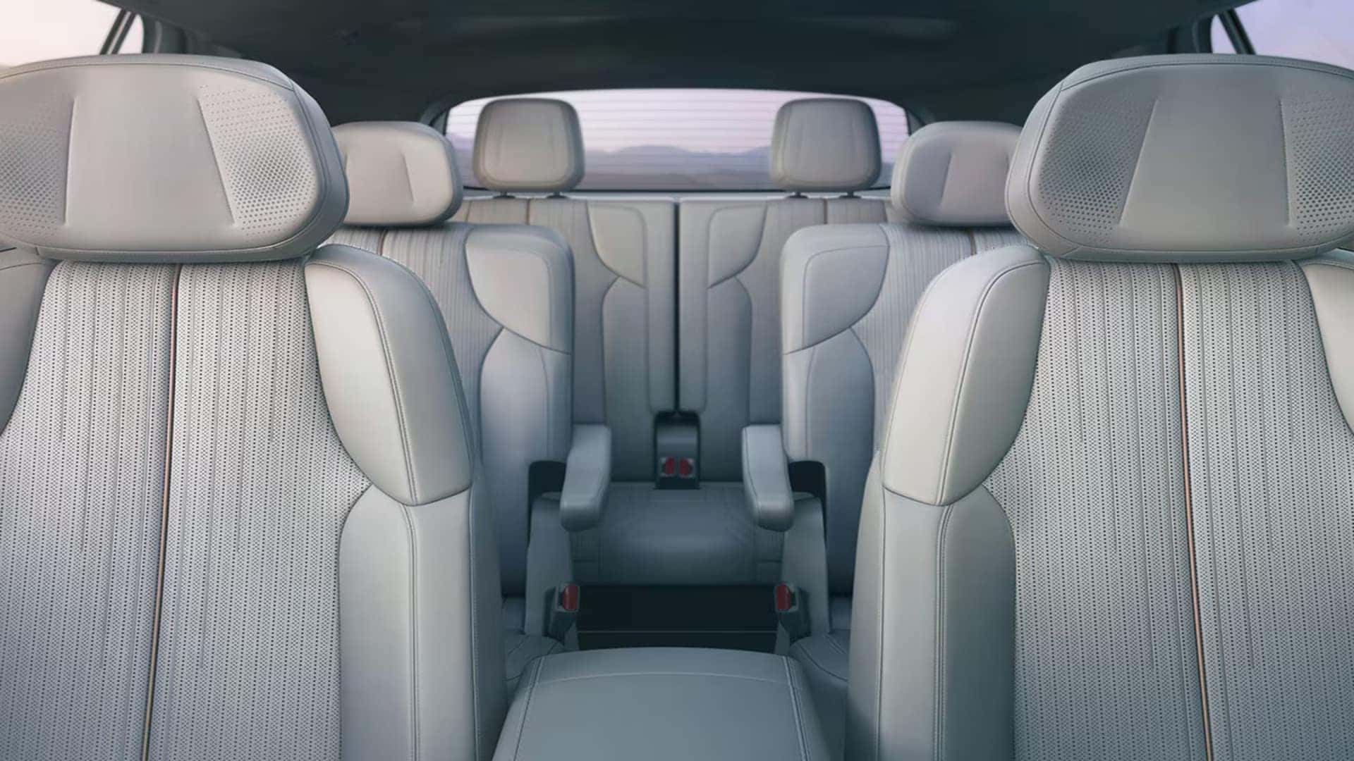 2026 Cadillac VISTIQ cabin with white front seats, second-row captain’s chairs, and third-row seating for passengers