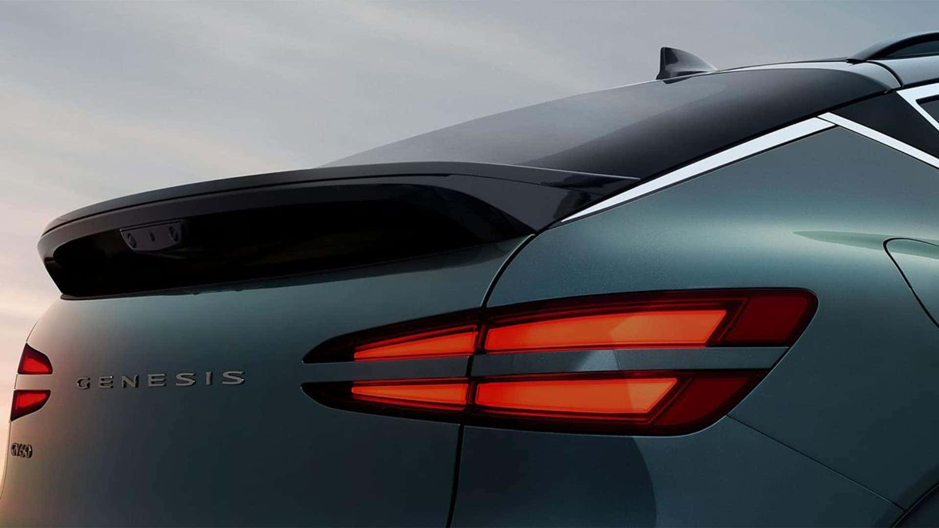 Rear close up of 2026 Genesis GV60 showing Two-Line LED taillights, liftgate badging, and sculpted rear spoiler