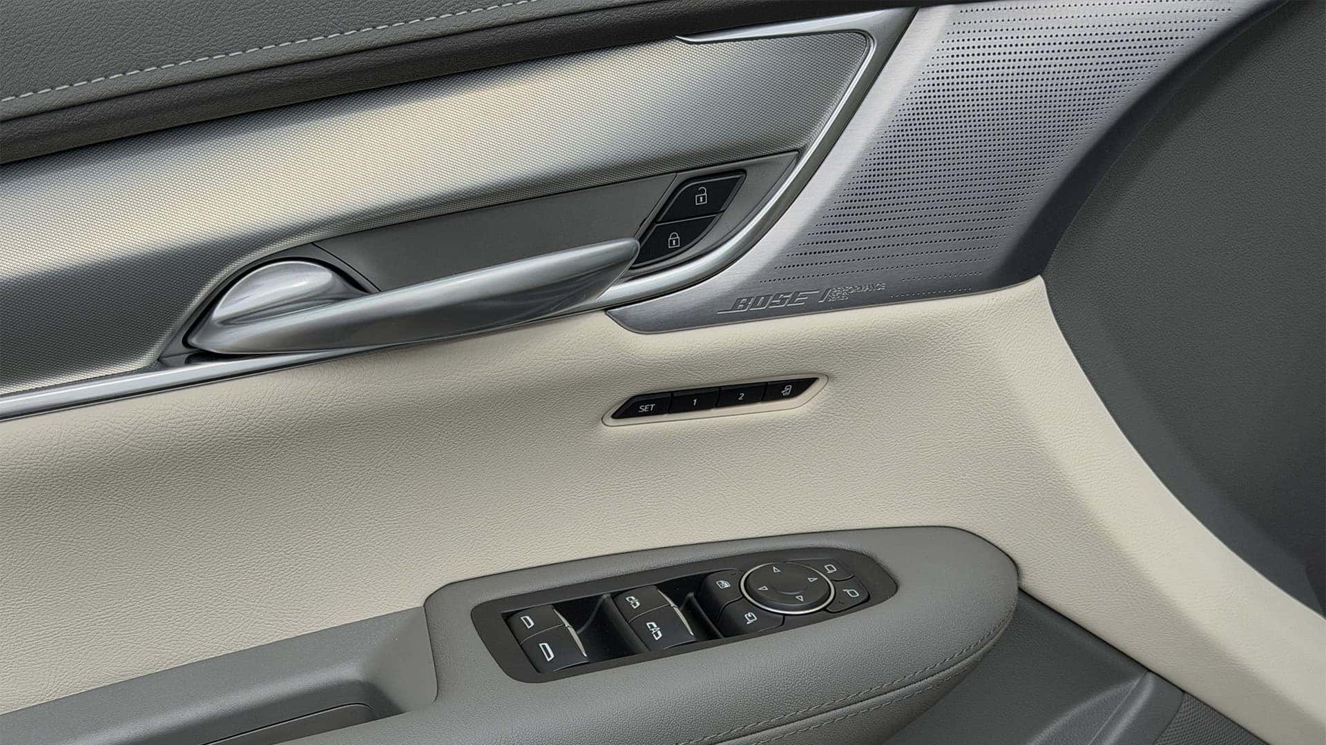2026 Cadillac XT5 interior door panel with Bose Performance speaker grille, memory seat buttons, and window controls
