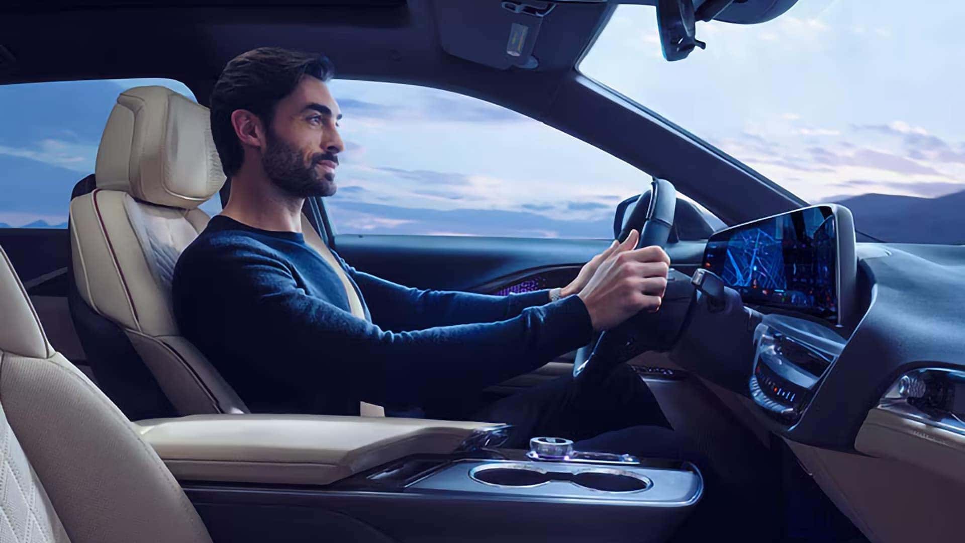 Driver seated in the 2026 Cadillac LYRIQ with infotainment display, steering wheel controls, and premium front cabin layout
