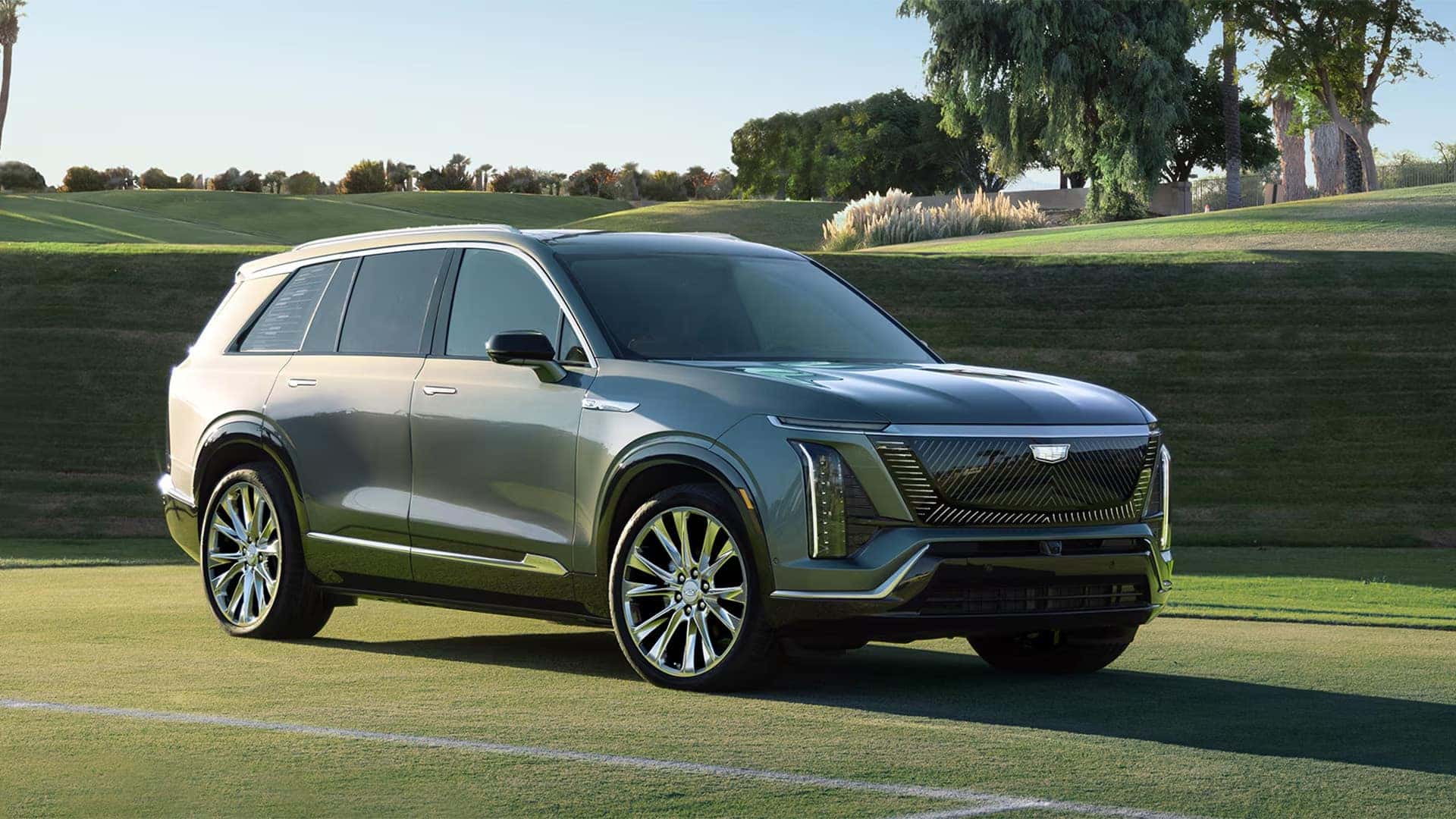 Silver 2026 Cadillac VISTIQ shown from the front passenger side with black roof, roof rails, LED lighting, and polished wheels
