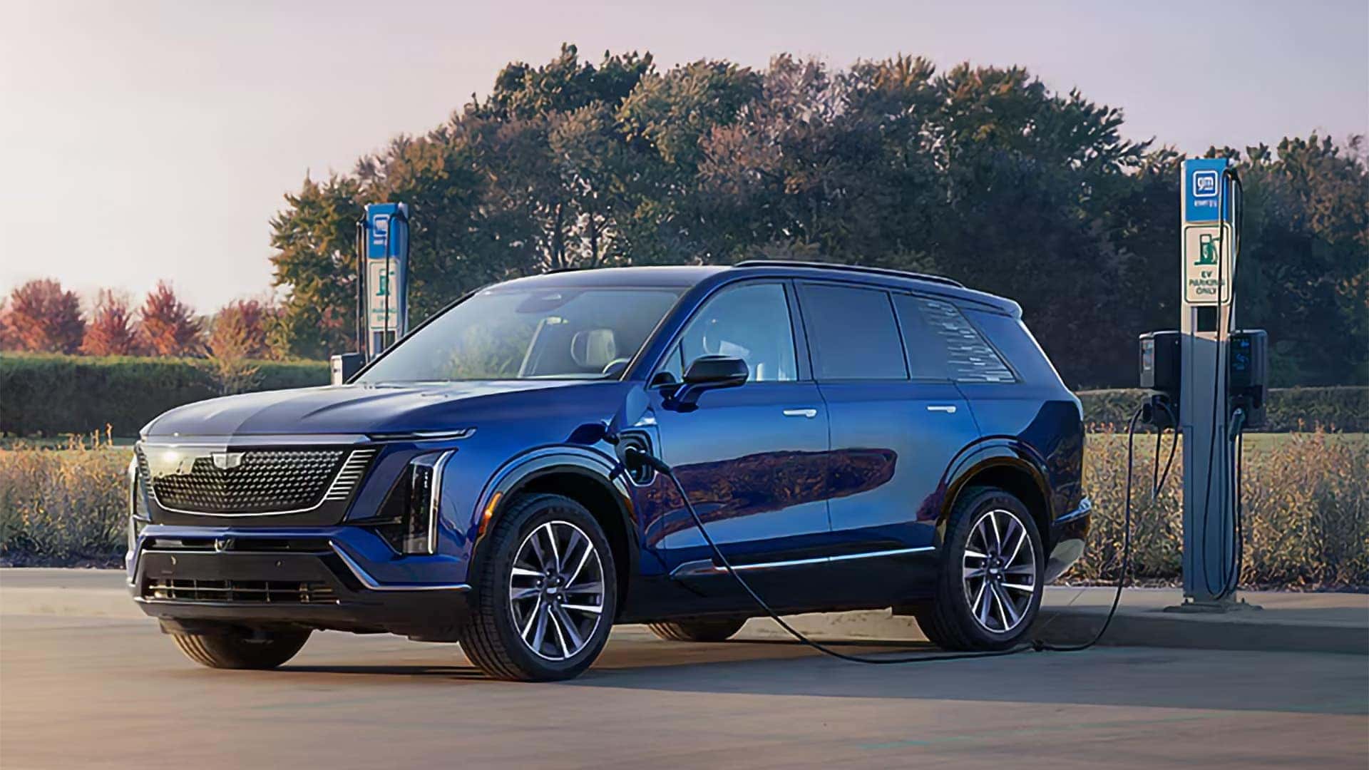 Blue 2026 Cadillac VISTIQ electric SUV charging at a public EV charging station