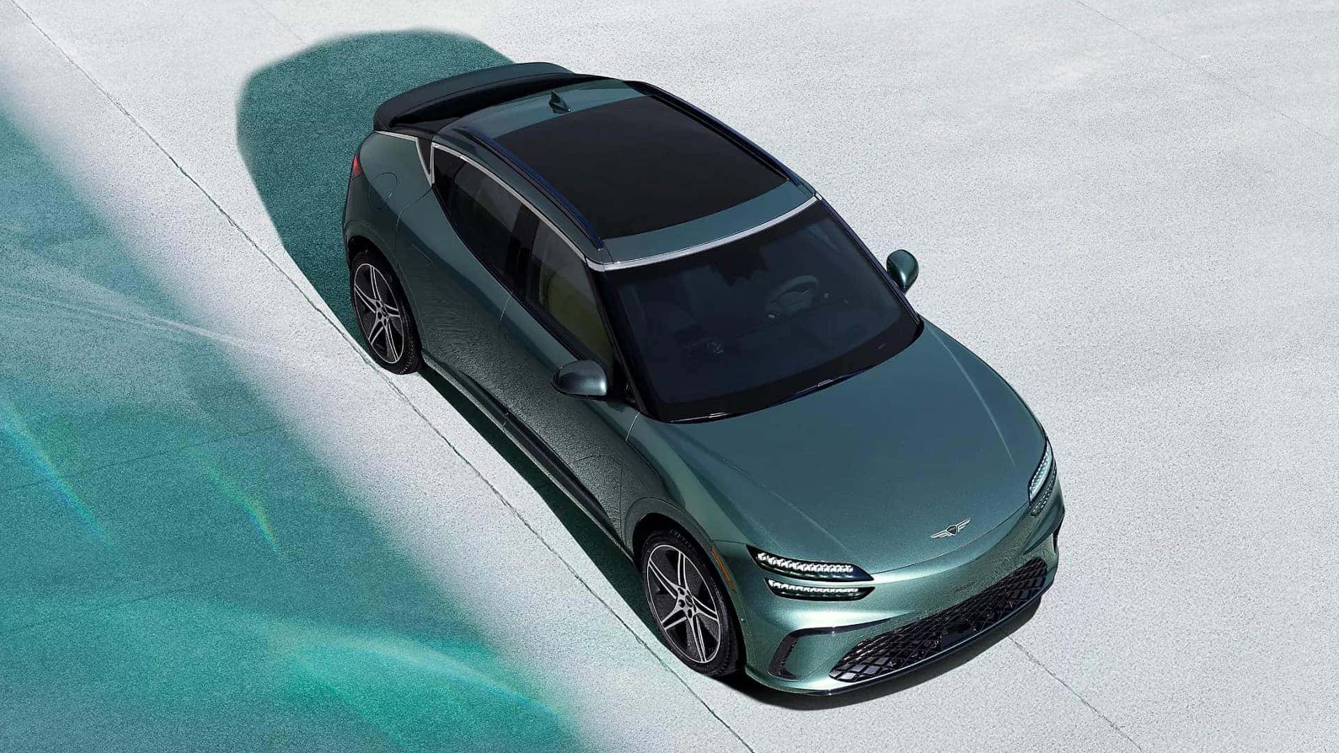 Overhead view of 2026 Genesis GV60 showing Vision Roof, black roof panel, roof rails, and sculpted exterior body lines