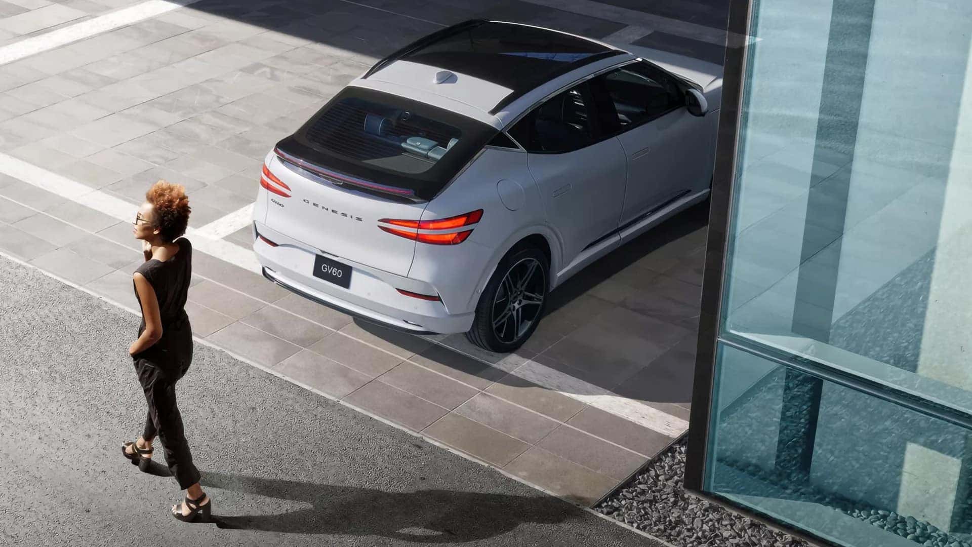 2026 Genesis GV60 parked near modern architecture with overhead view of rear lighting and glass roof