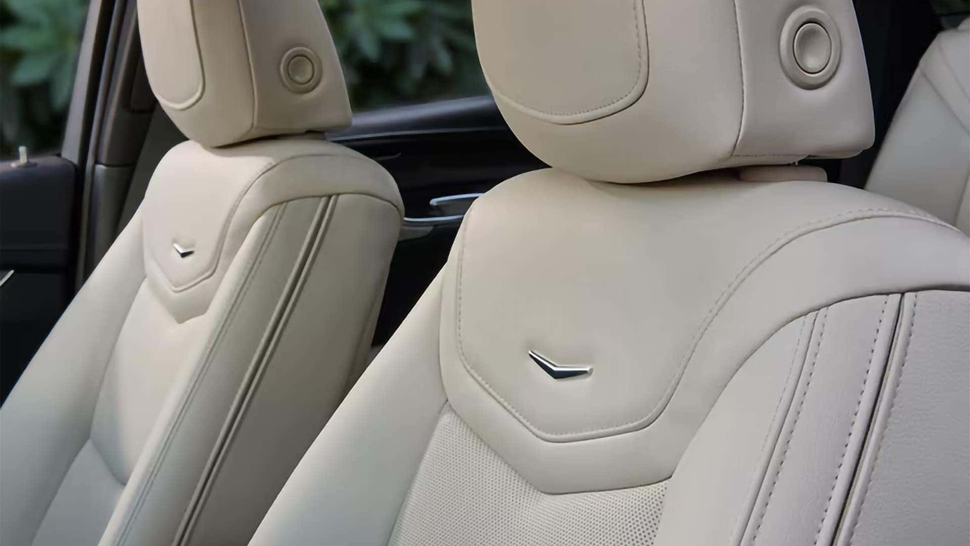 2026 Cadillac XT5 front seats with light leather upholstery, detailed stitching, and Cadillac seatback accents