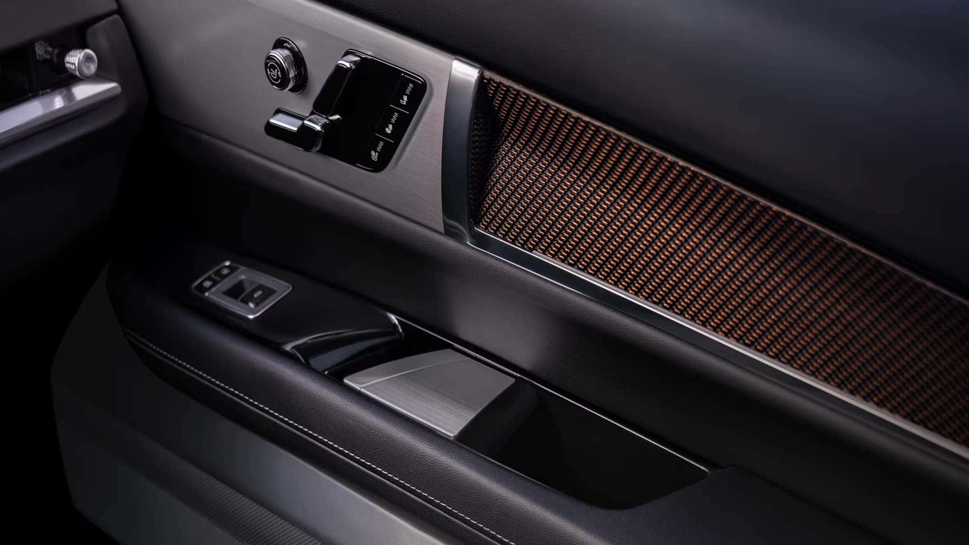 2026 Cadillac VISTIQ door panel with seat controls, metallic trim, premium speaker grille, and interior storage area