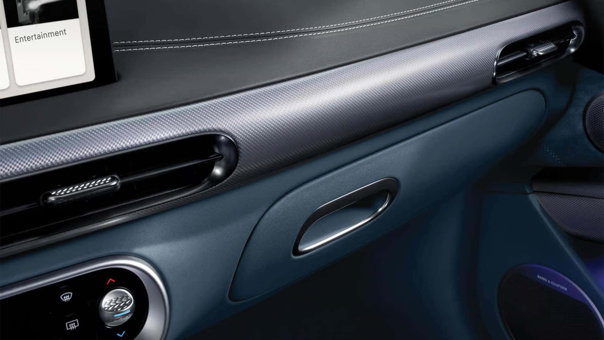 2026 Genesis GV60 dashboard trim with premium materials, slim air vents, climate controls, and Bang and Olufsen speaker