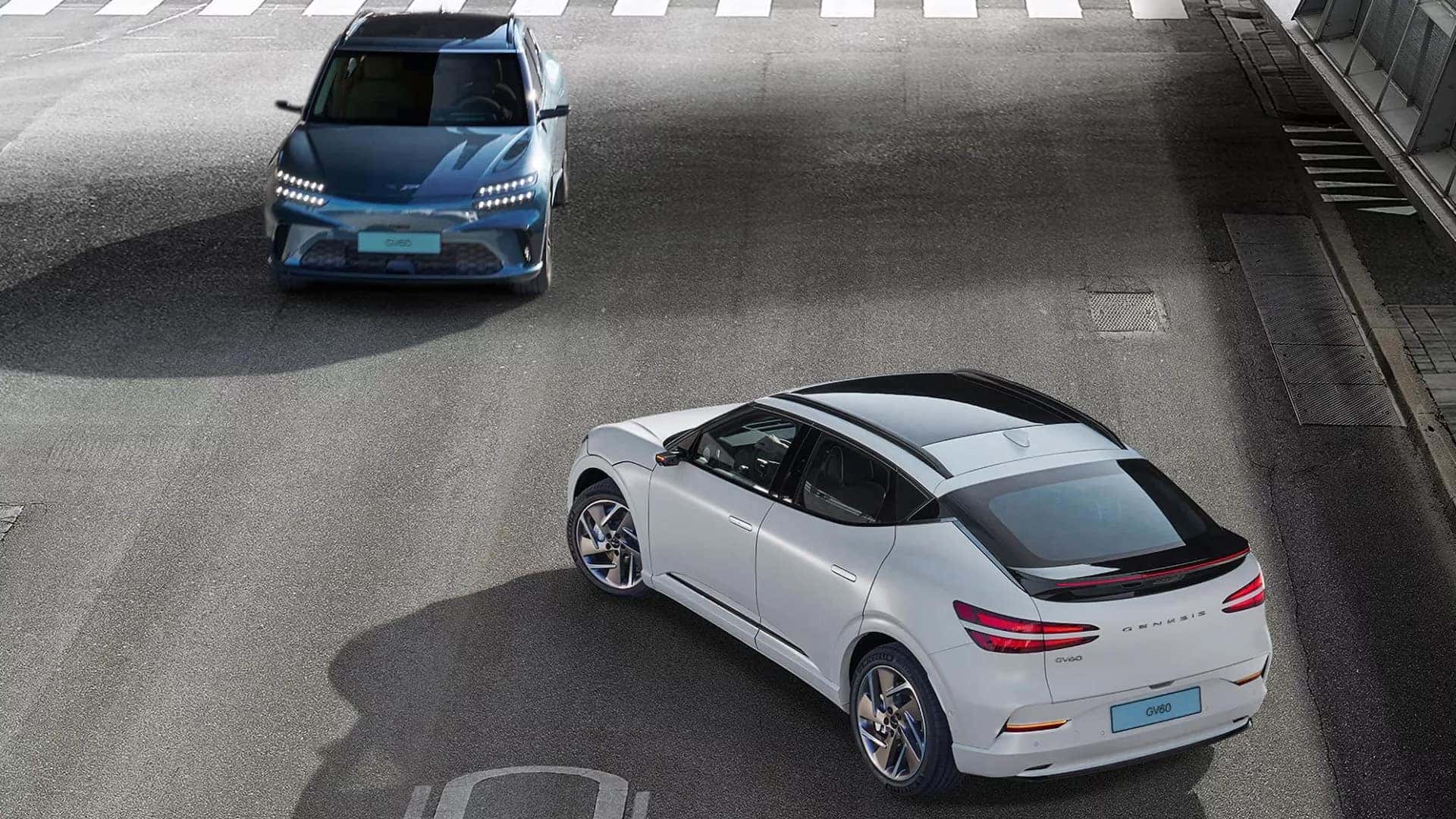 2026 Genesis GV60 models in a parking area showing driver assistance and safety technology in urban driving