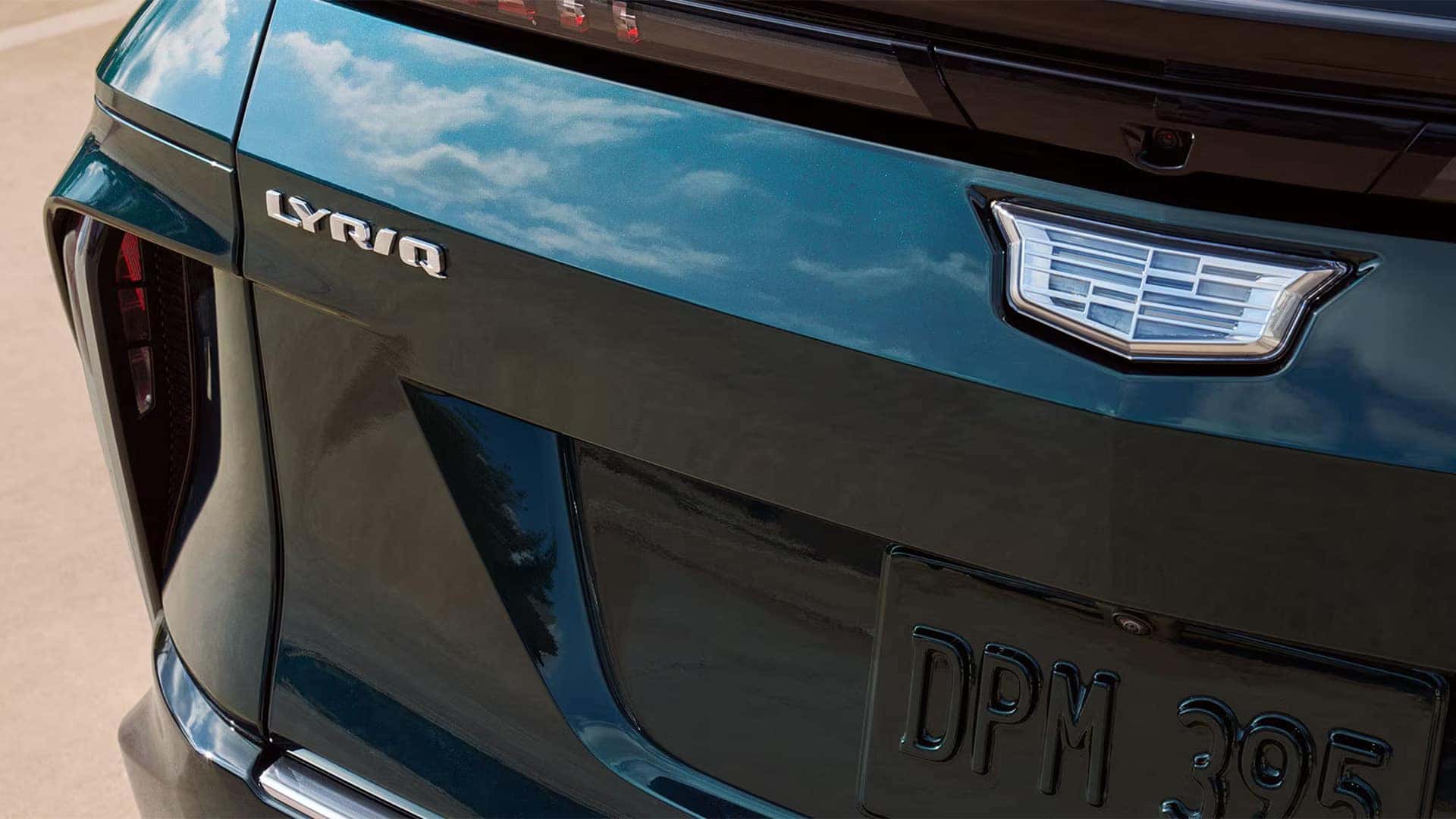 Close-up of 2026 Cadillac LYRIQ rear badge, Cadillac crest, camera, taillight, and exterior paint detail