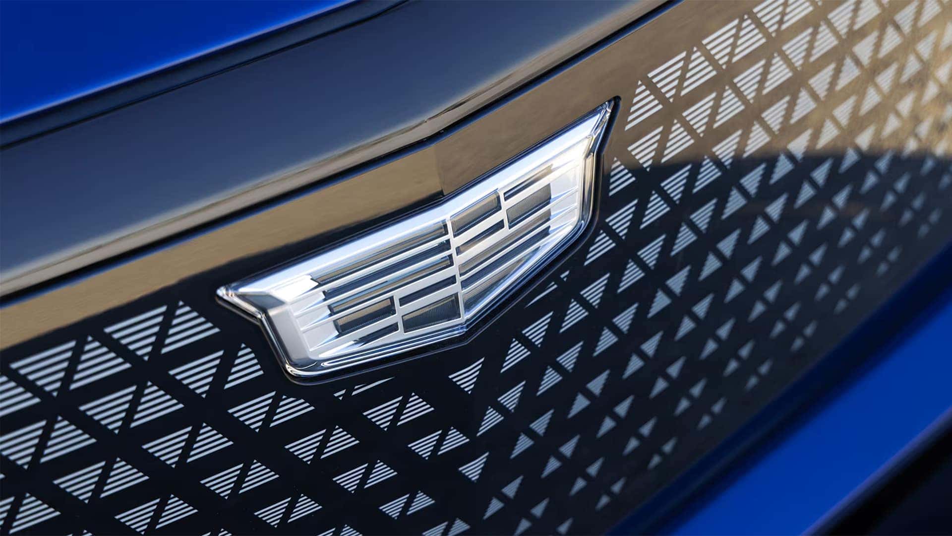 Close up of the 2026 Cadillac VISTIQ grille with Cadillac crest and illuminated patterned front design