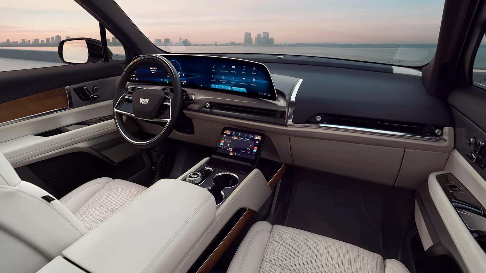 2026 Cadillac VISTIQ front interior with white seats, wood trim, center touchscreen, and curved 33-inch display
