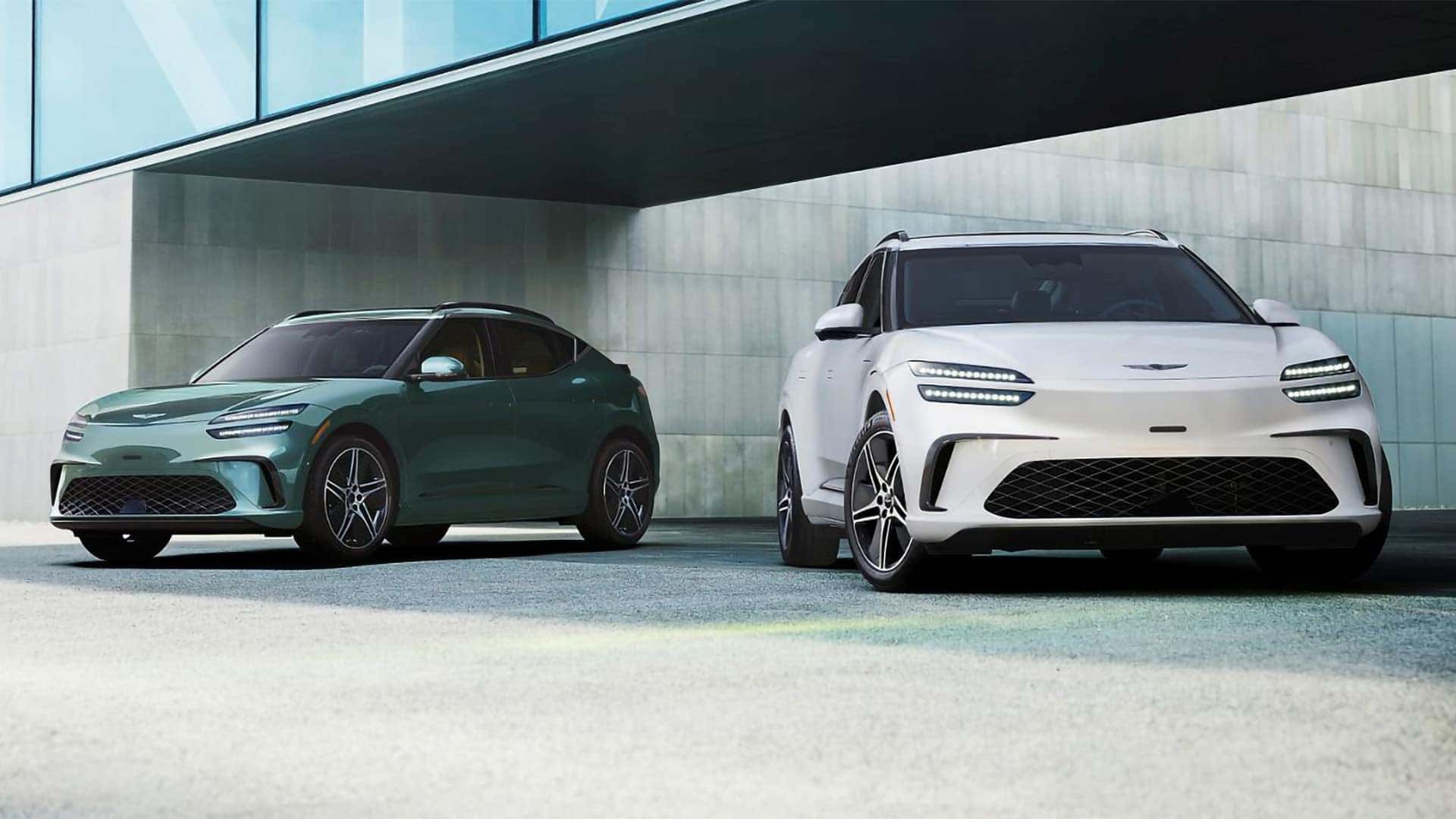 Two 2026 Genesis GV60 electric SUVs parked side by side showing white and green exterior color options