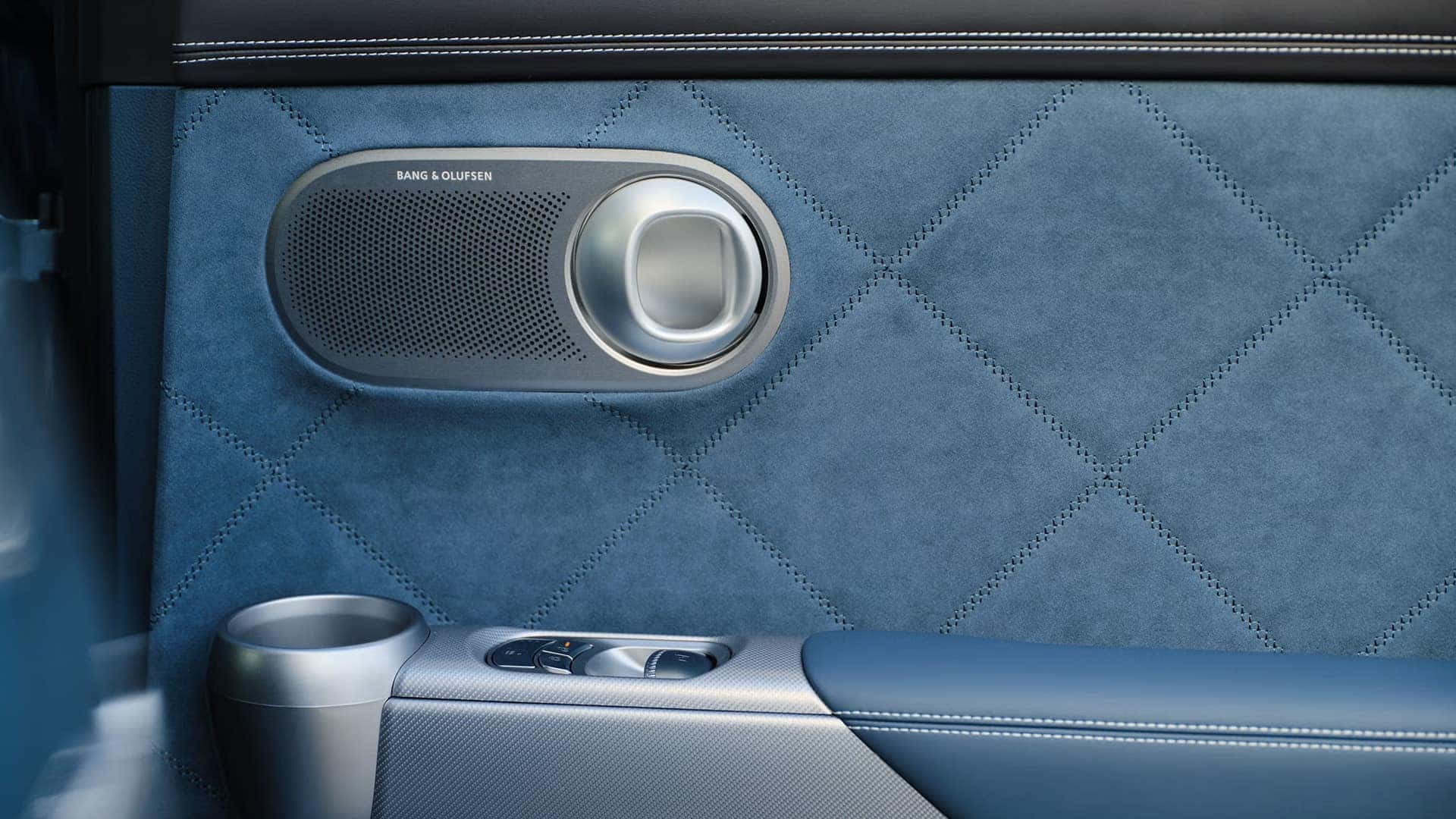 Bang and Olufsen speaker inside the 2026 Genesis GV60 with blue quilted door trim and premium audio technology