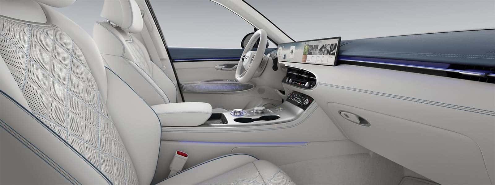2026 Genesis Electrified GV70 interior with white quilted seats, ambient lighting, and a wide digital dashboard display