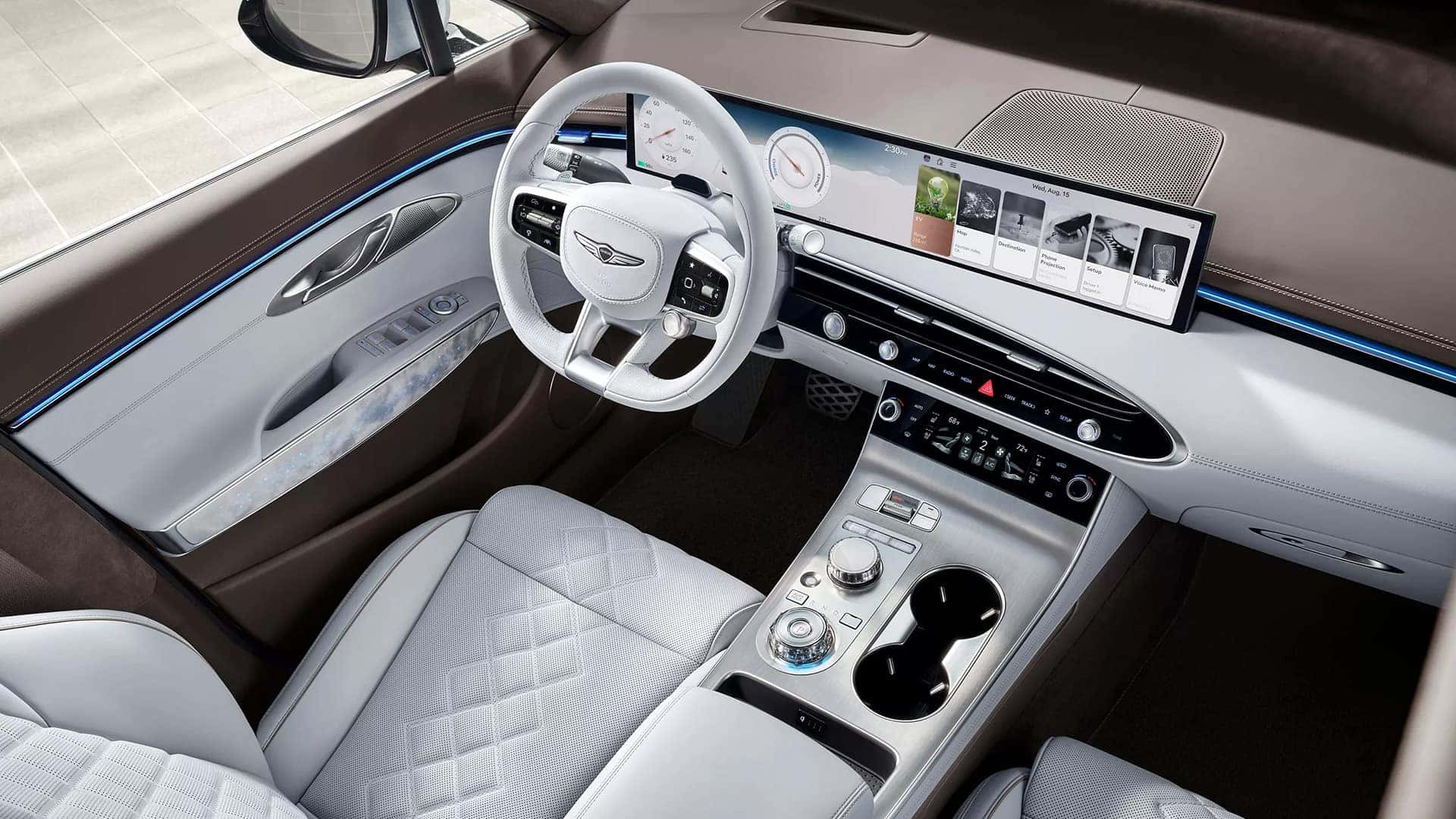 2026 Genesis Electrified GV70 cockpit with 27-inch OLED display, rotary controls, ambient lighting, and white leather seating