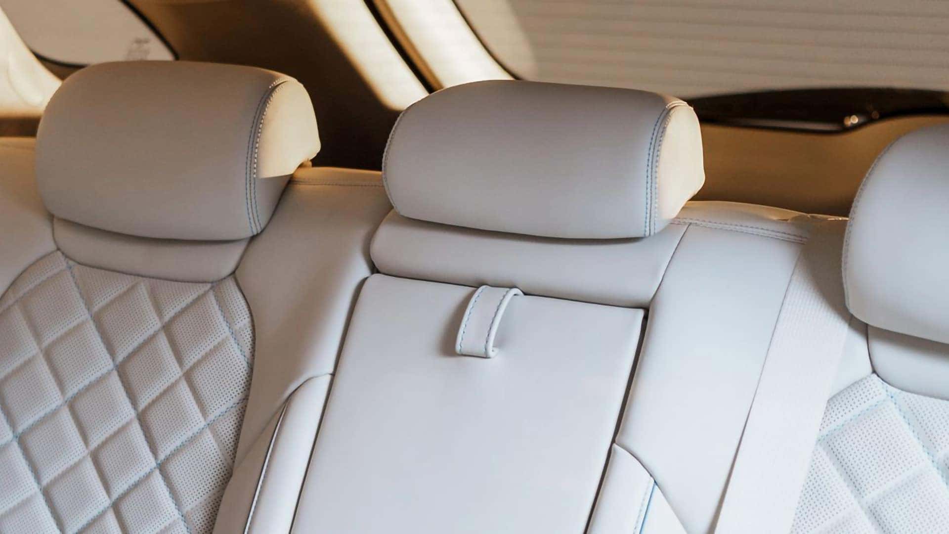 Rear seating area of the 2026 Genesis Electrified GV70 with quilted white upholstery, three head restraints, and center armrest