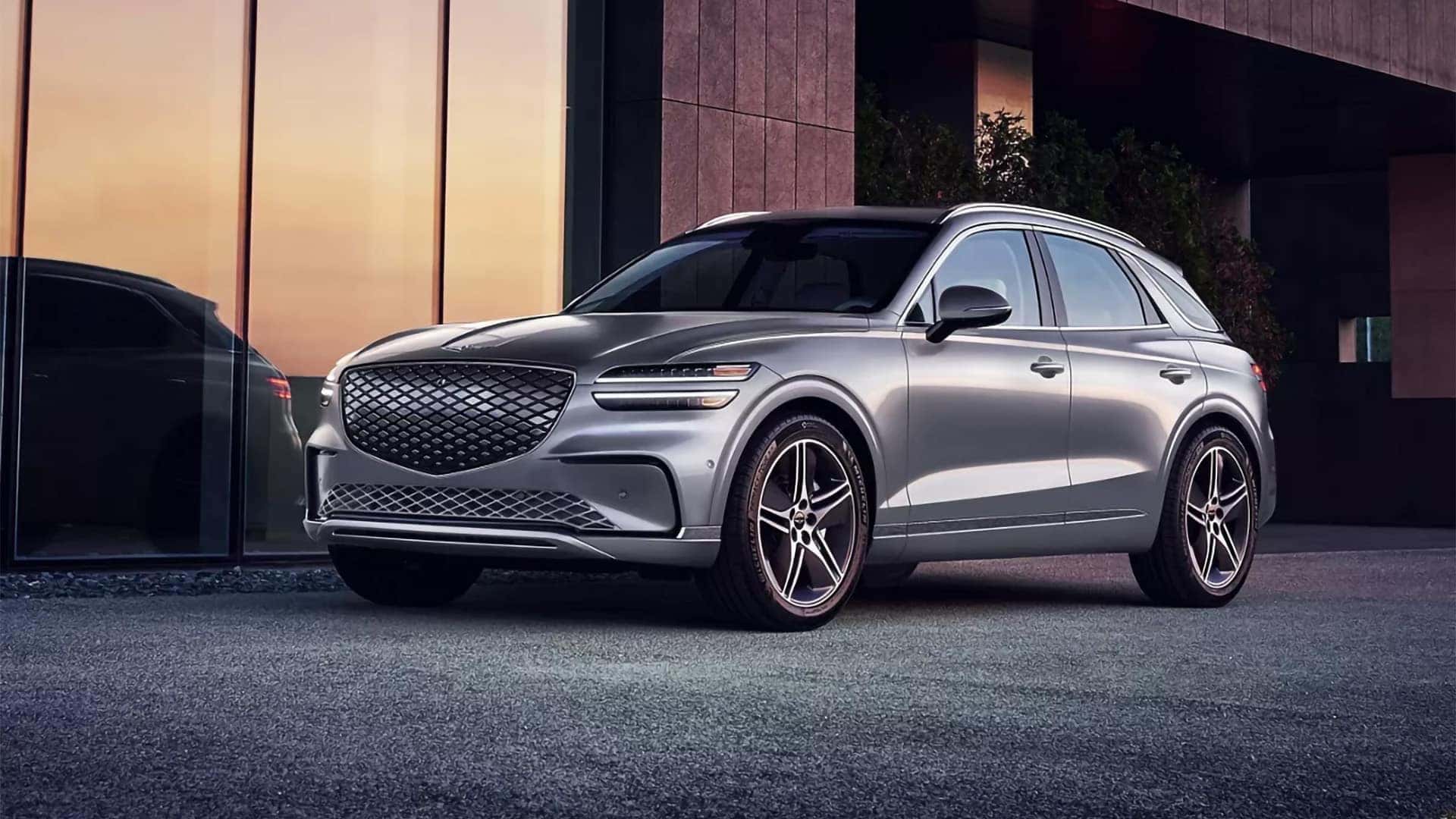 2026 Genesis Electrified GV70 parked at sunset outside a modern building